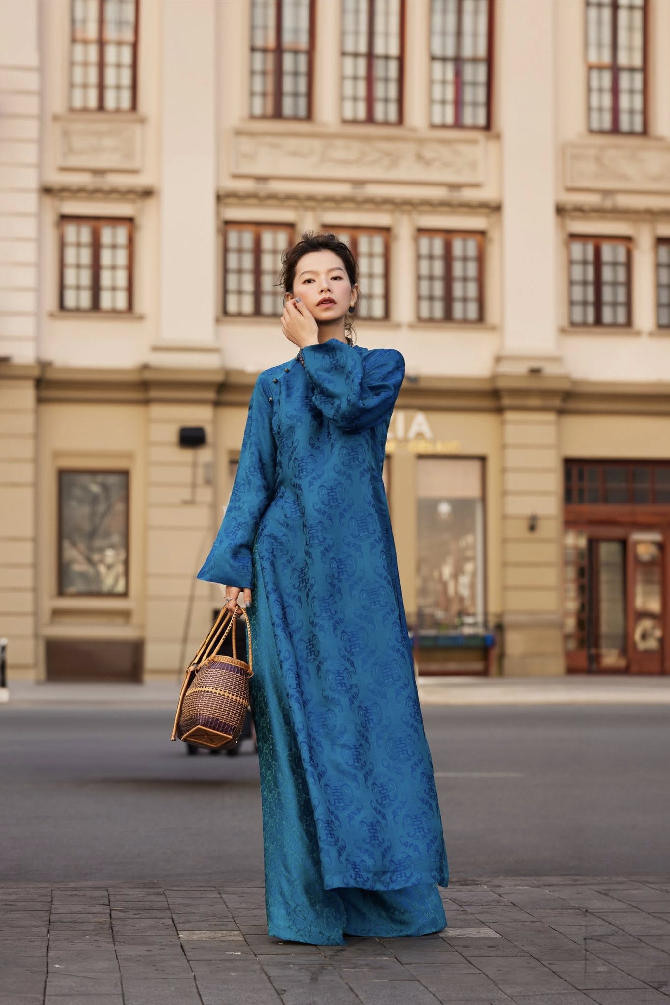 Woman wearing Celestial Indigo imperial teal wormsilk áo dài with stone buttons and straight-cut silhouette - Lo Boutique luxury Vietnamese fashion