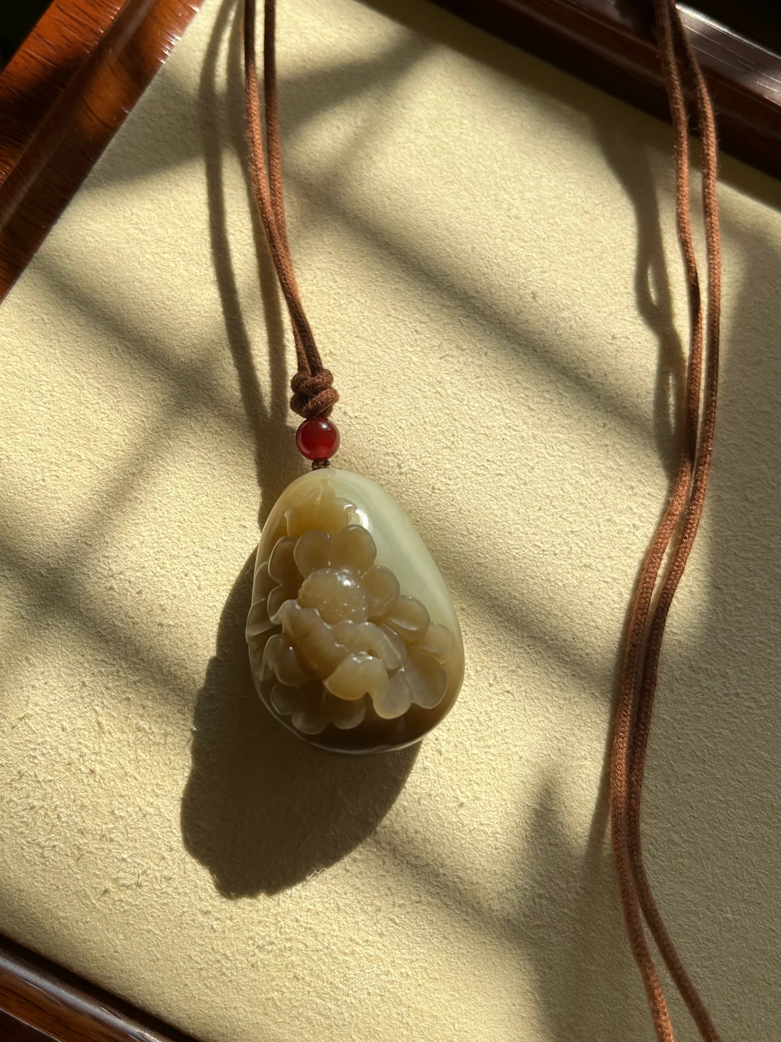“Amber Peony” - Brown Hetian Jade Peony Flower Pendant - flat lay display in beige by L'Orient Haus