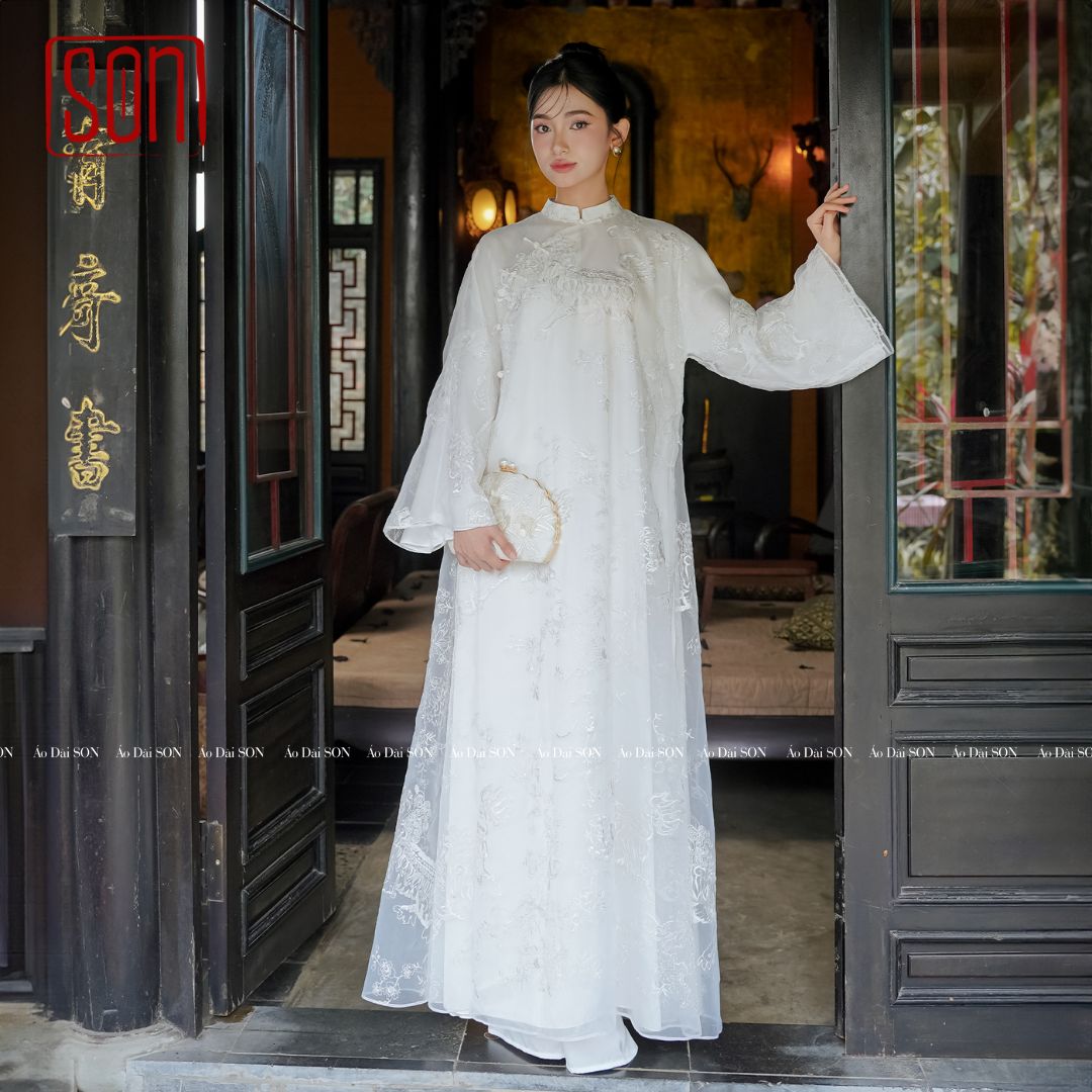 "Uyen Son embroidered white organza Ao Dai set, traditional Vietnamese wedding dress with floral silk pattern."