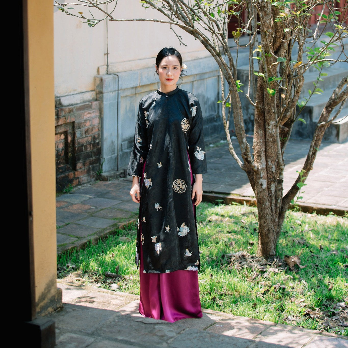 "Traditional Vietnamese Ao dai in black silk with floral embroidery, artisan design"