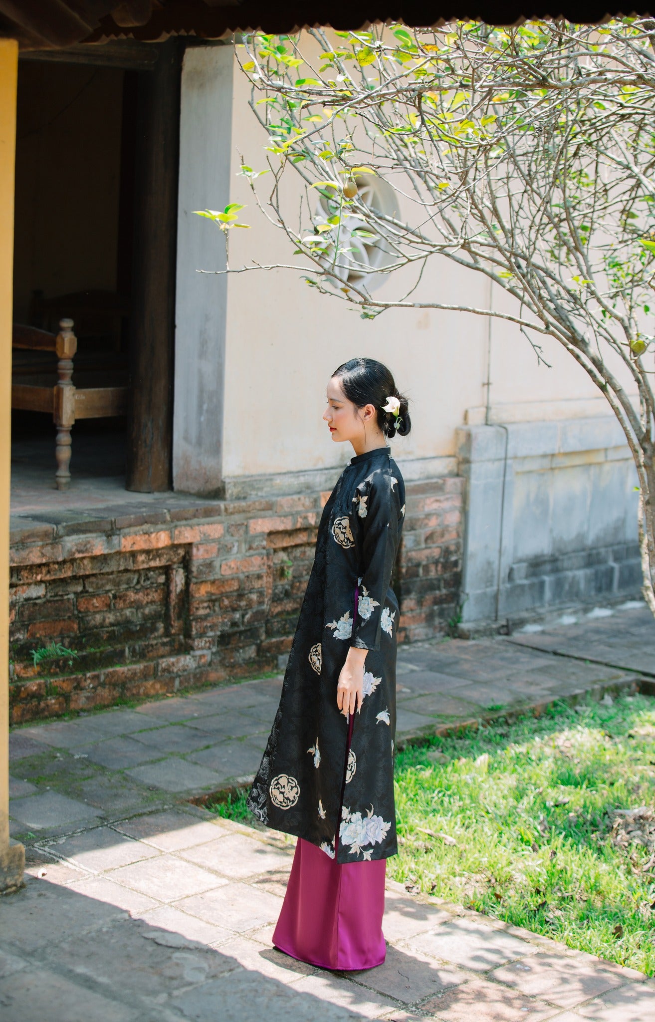 "Traditional Vietnamese Ao dai in black silk with floral embroidery, showcasing cultural heritage."