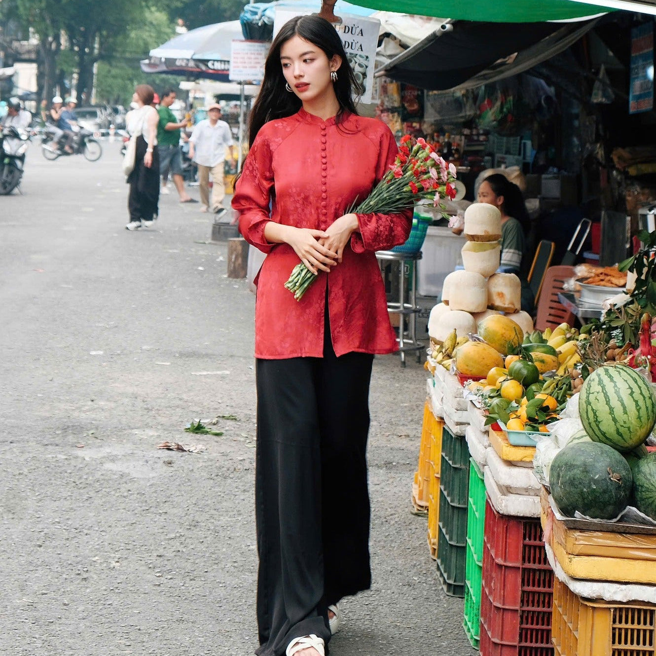 Detailed view of festive scarlet silk fabric with plum blossom branches in tonal jacquard pattern on Nhu Y Ba Ba top