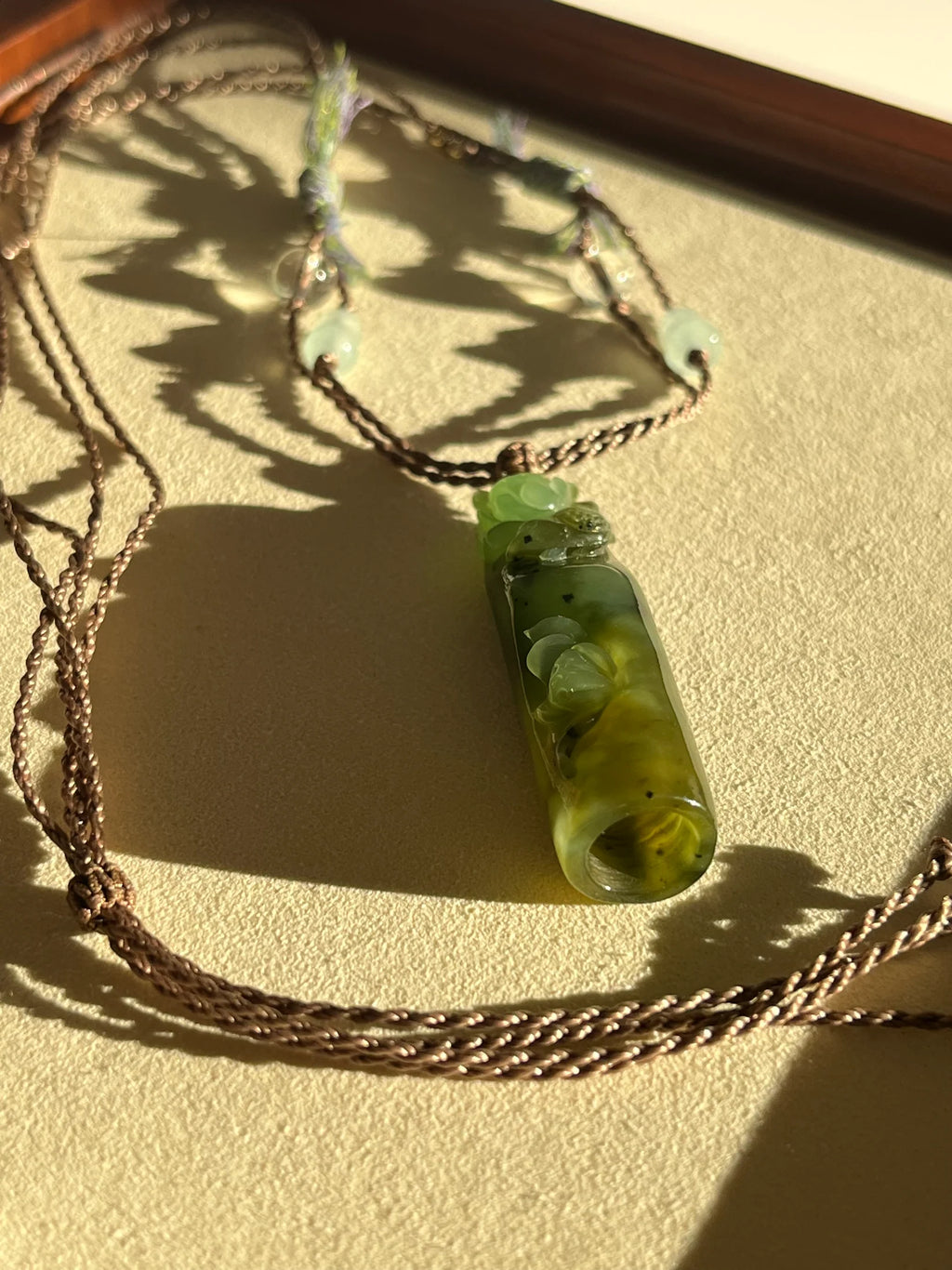 “Song of the Lotus” - Hand Carved Green Hetian Jade Lotus and Magpie Pendant | 手雕和田碧玉喜鹊荷花吊坠 - flat lay display