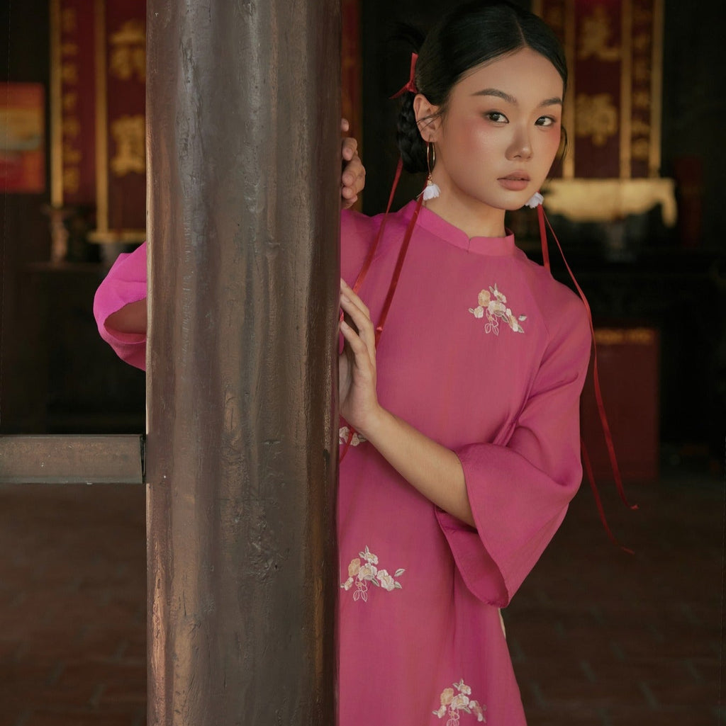"Traditional Vietnamese Ao dai in pink chiffon with floral pattern, cultural authenticity."