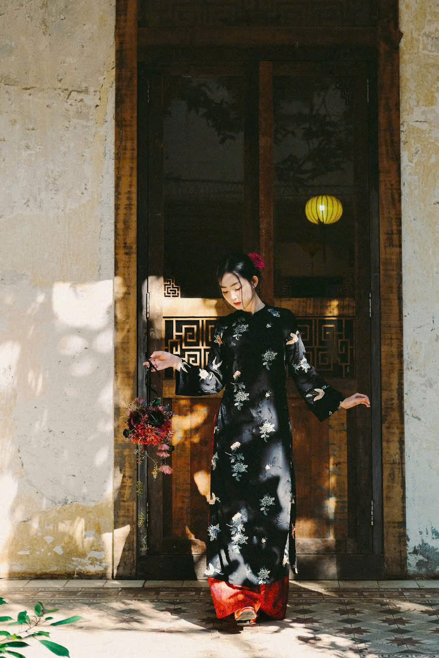 "Traditional Vietnamese Ao dai in black silk with floral embroidery, artisan-crafted."