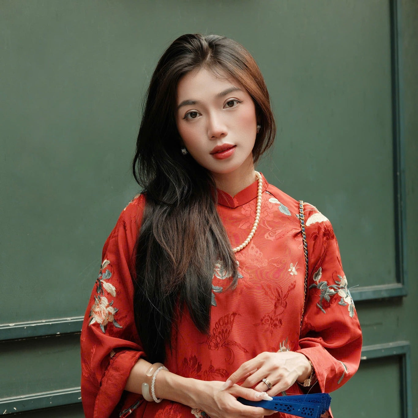 A person wearing a red floral dress with traditional patterns