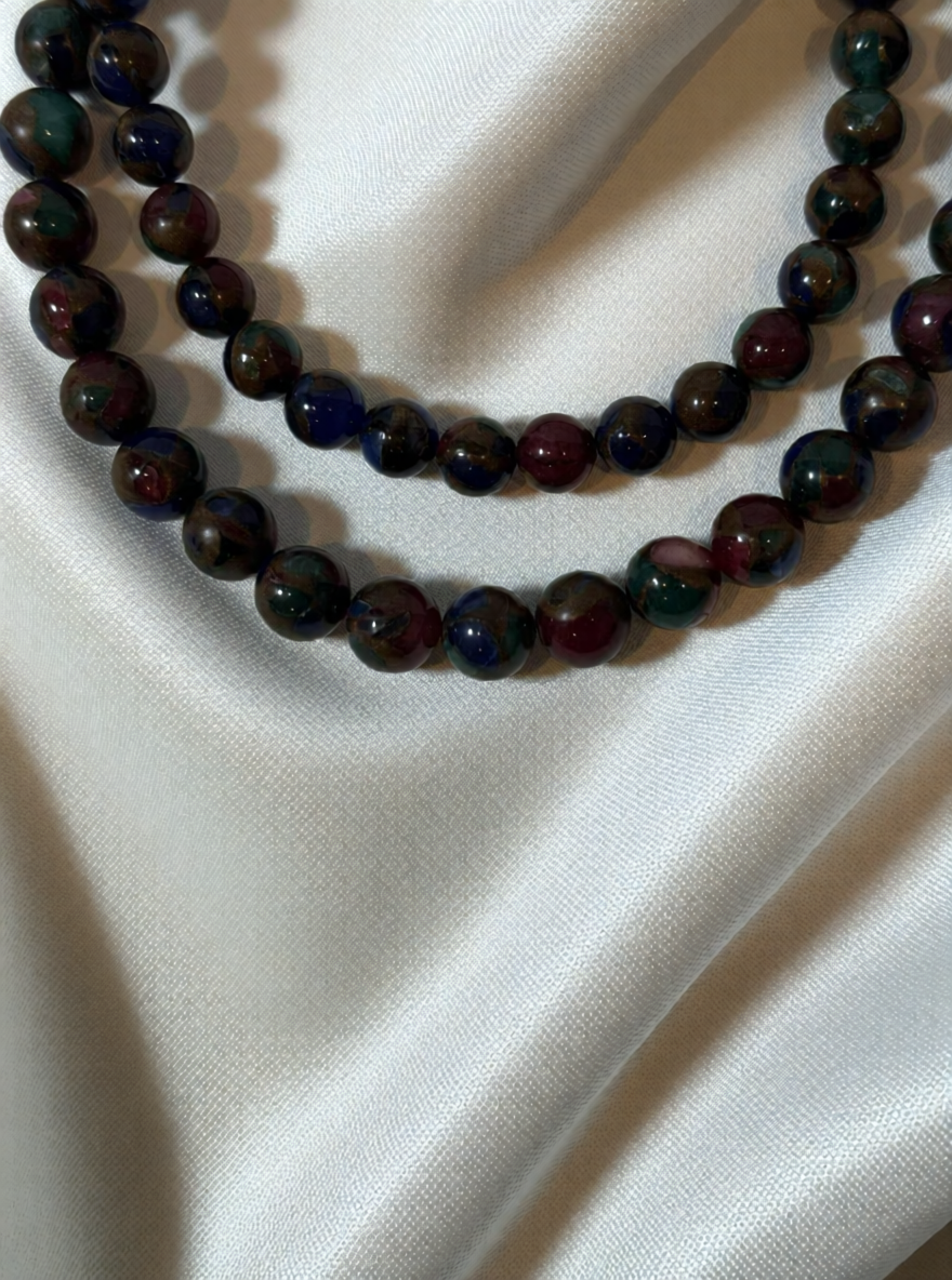 Necklace with multicolored beads on a white fabric background