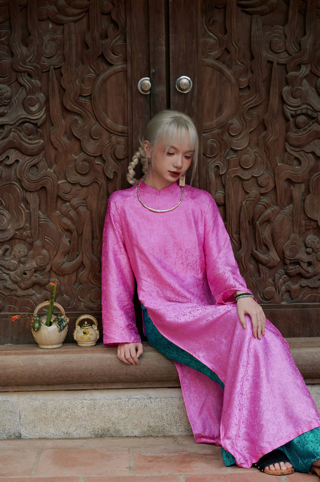 "Traditional Vietnamese Ao dai in pink wormsilk with green accents, cultural artisan design"