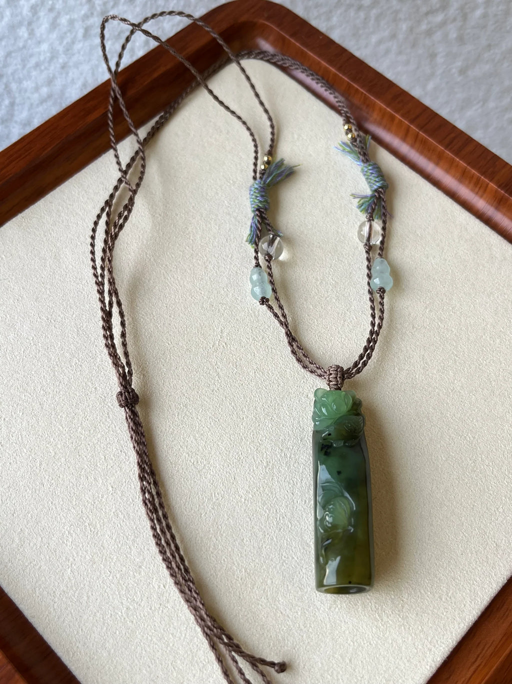 “Song of the Lotus” - Hand Carved Green Hetian Jade Lotus and Magpie Pendant | 手雕和田碧玉喜鹊荷花吊坠 - flat lay display
