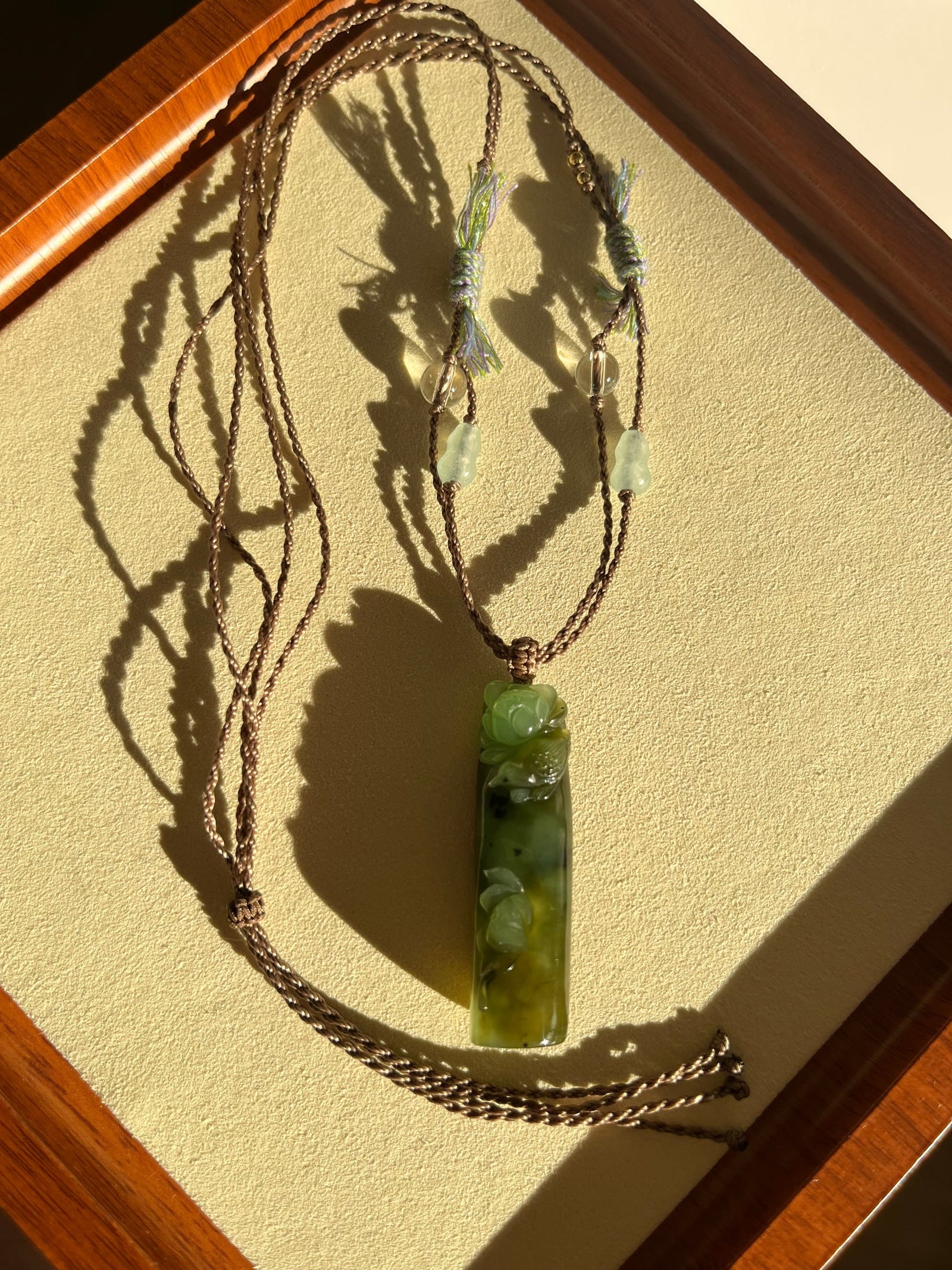 “Song of the Lotus” - Hand Carved Green Hetian Jade Lotus and Magpie Pendant | 手雕和田碧玉喜鹊荷花吊坠 - flat lay display