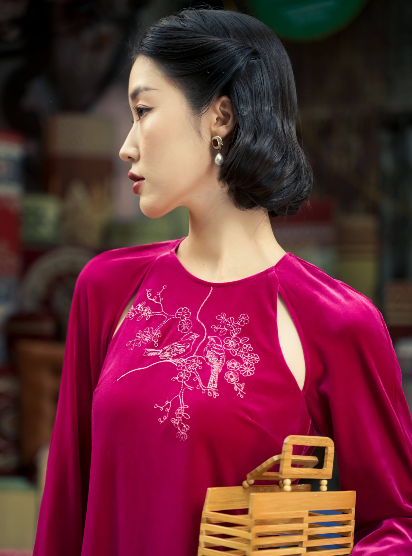 "Diem Quyen Ao Dai Halter Dress in red velvet with cut-out embroidery, showcasing Vietnamese artisan heritage."