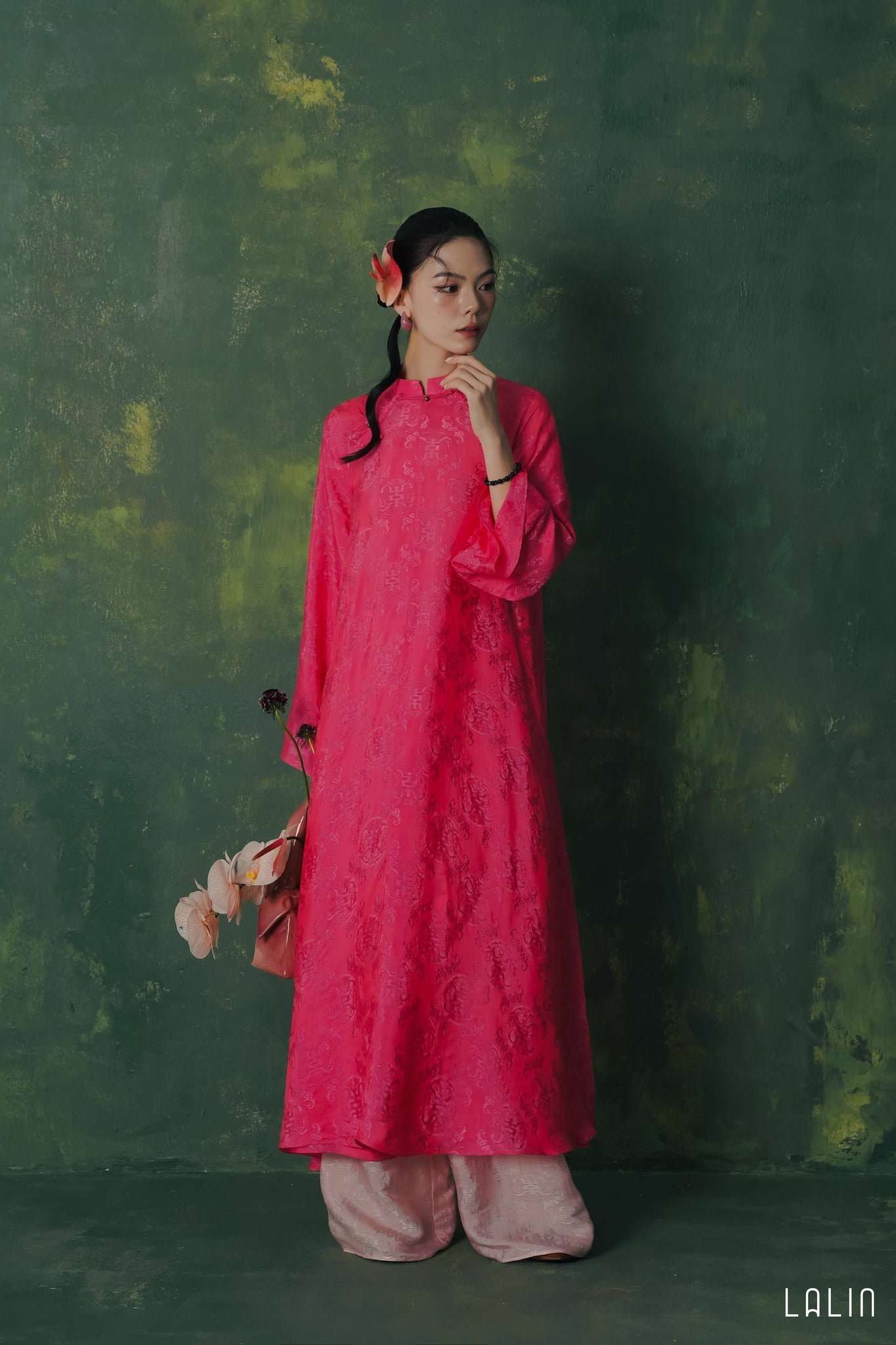 "Diep Dan Ao Dai Set in bright peach silk by Lalin, traditional Vietnamese dress with modern artisan patterns."
