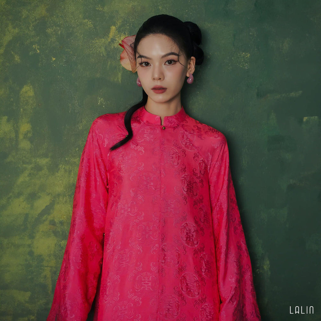 "Diep Dan Ao Dai Set in bright peach silk by Lalin, traditional Vietnamese dress with modern patterns."