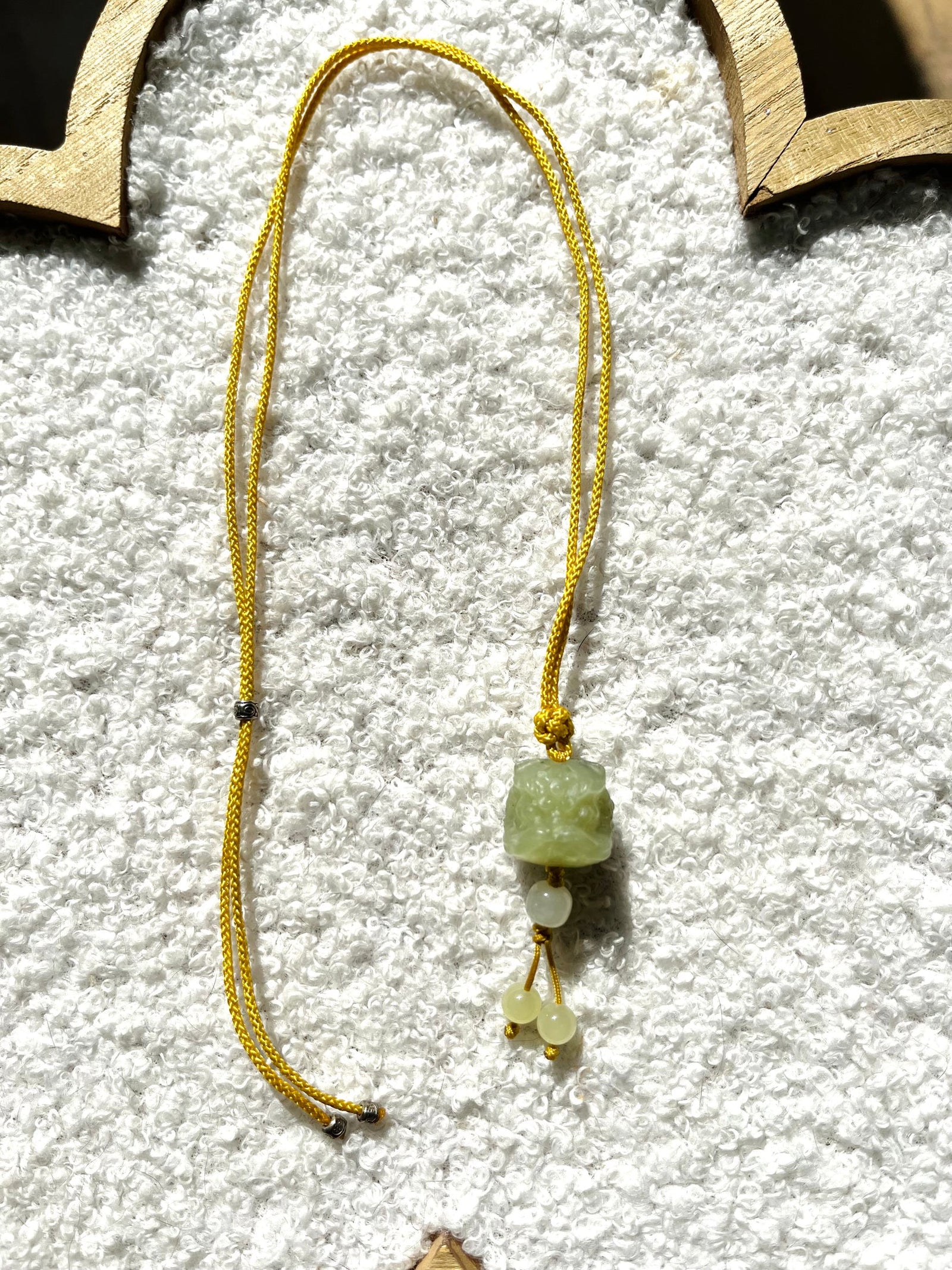 Guardian's Fortune – Hand-Carved Hetian Jade Lion Dance Charm - flat lay display by L'Orient Haus