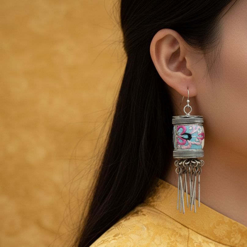 Bloom cylinder earrings flatlay showing embroidery detail and sterling silver