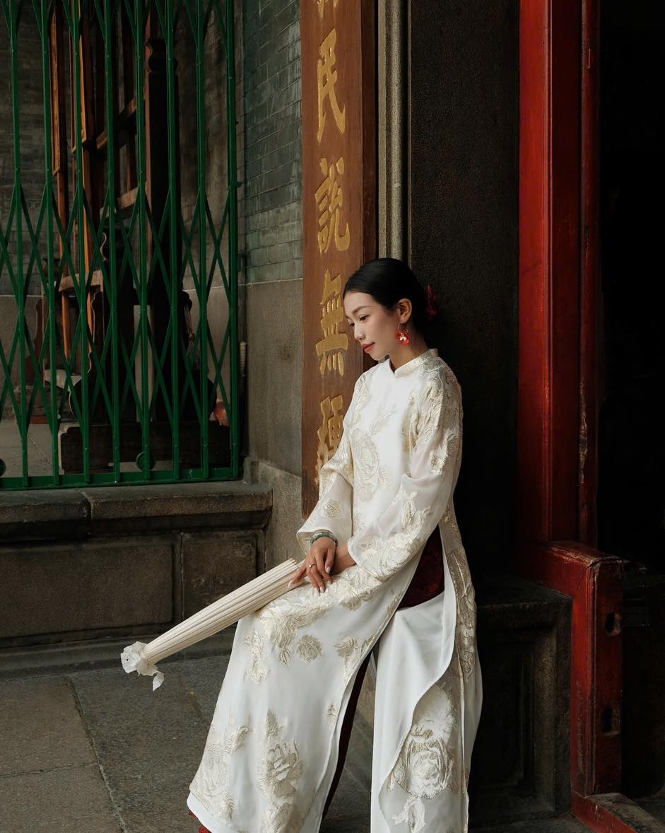 "Traditional Vietnamese Ao dai in white flowery silk, artisan-crafted, cultural heritage attire"