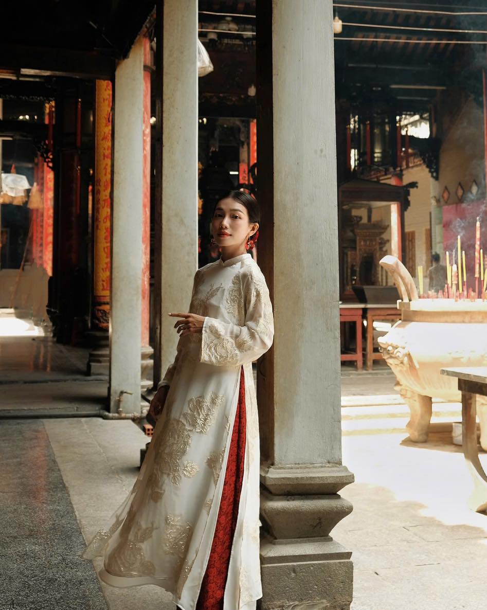 "Traditional Vietnamese Ao dai in white silk with red accents, artisan woven design, cultural heritage attire"