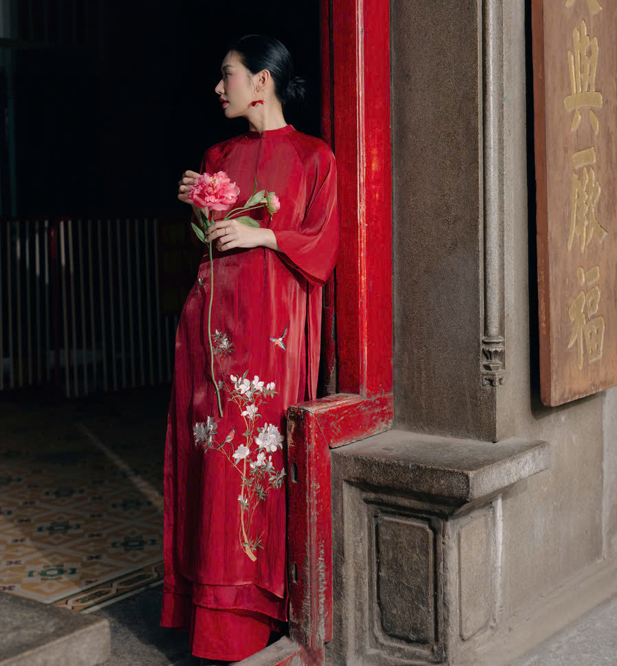 "Red silk 'Giao Mien' Ao Dai with floral embroidery, traditional Vietnamese dress by Moc."