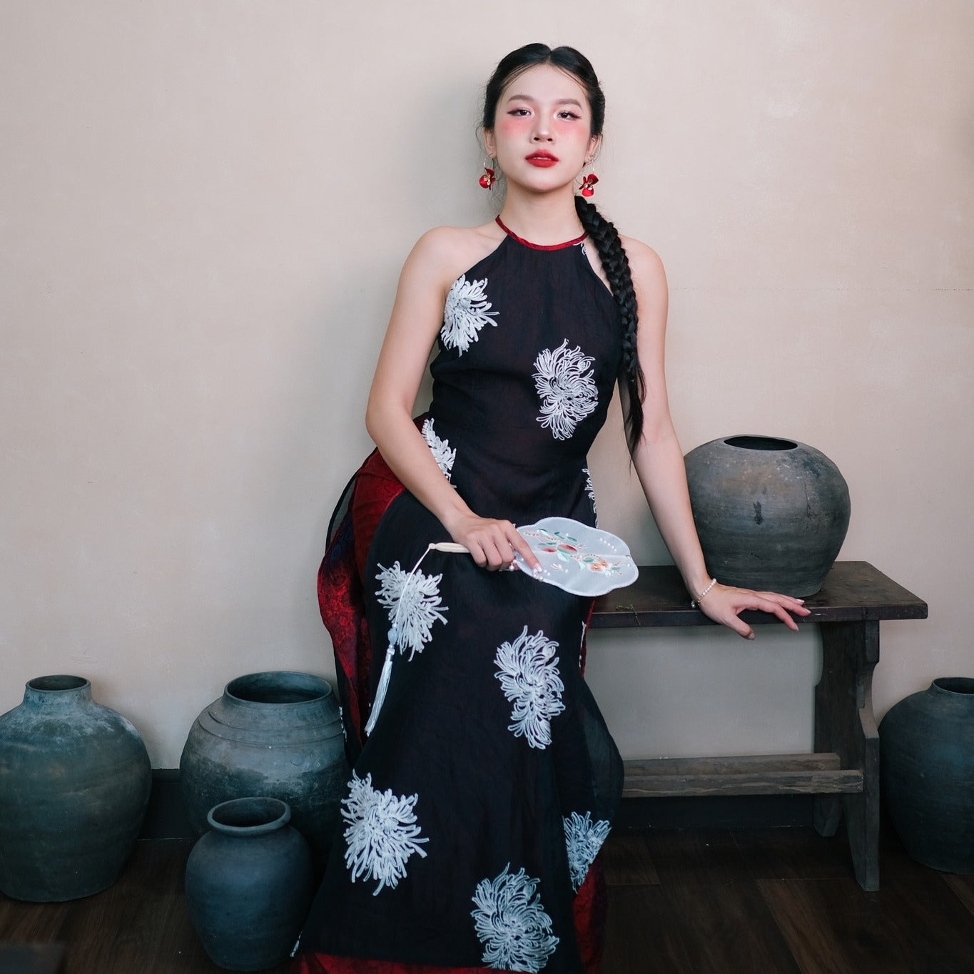 "Traditional Vietnamese Ao dai halter dress in black silk with red accents and floral embroidery."