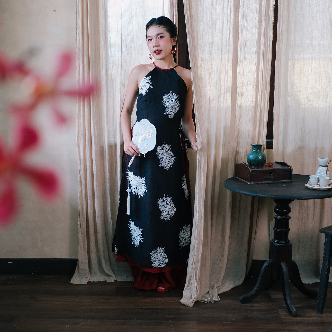 "Traditional Vietnamese Ao dai dress 'Giac Mong Dem He' in black silk with red accents and floral embroidery."