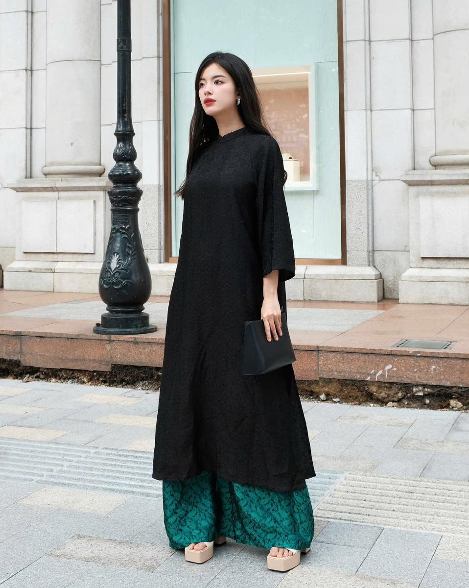 "Traditional Vietnamese 'Huyen Hoa' Ao dai set in black silkworm silk by Moc, featuring artisan craftsmanship and modern design."