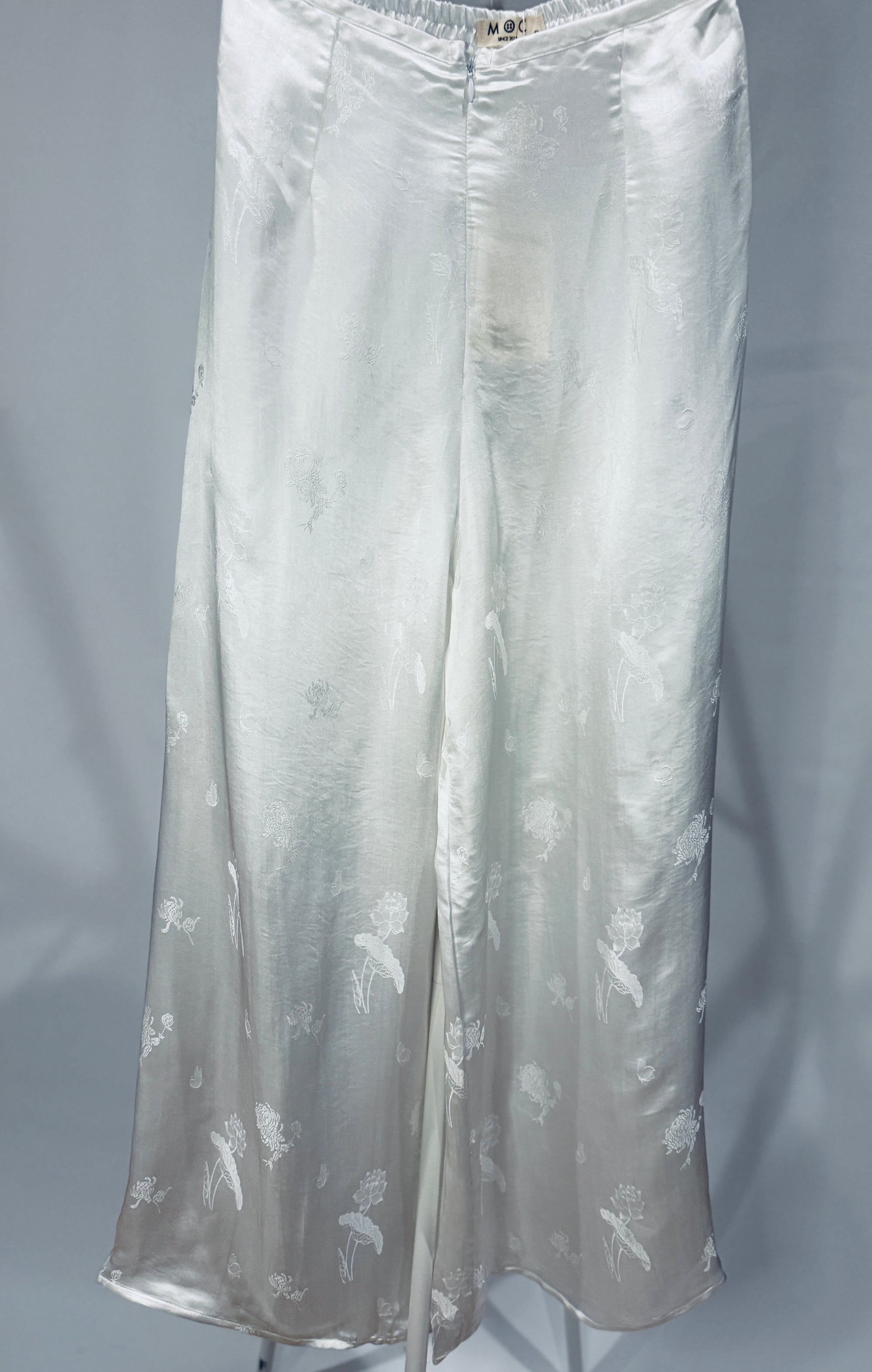"Lotus pattern Ao Dai pants in white silk jacquard, traditional Vietnamese design by Moc."