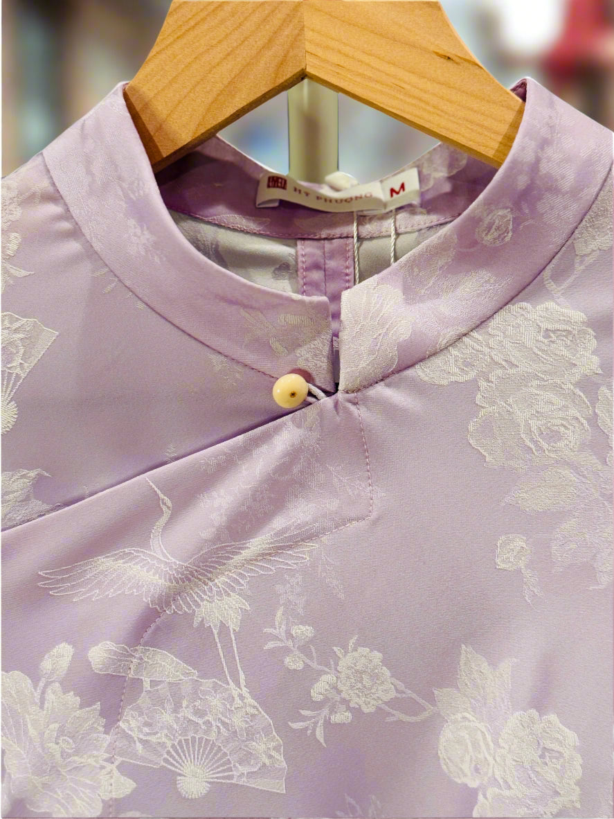 "Sleeveless lavender cheongsam top by Hy Phuong in silk jacquard with floral and crane patterns"