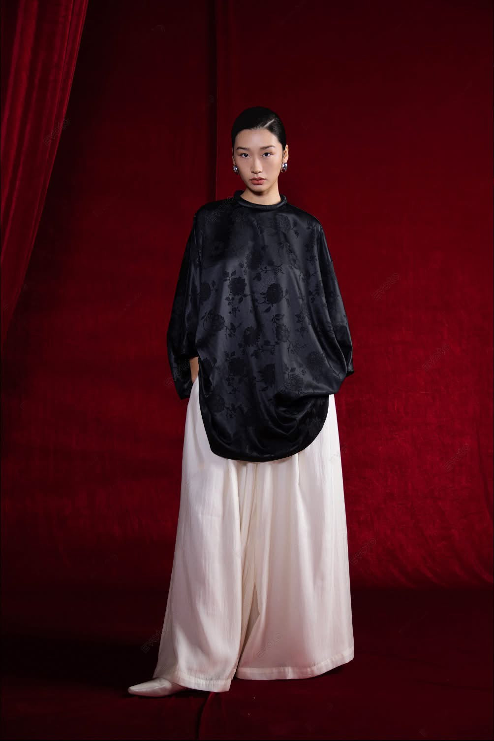 "Bich Tam" Set: Black floral jacquard top with round neckline, paired with white wide-leg "Bong Benh" pants.
