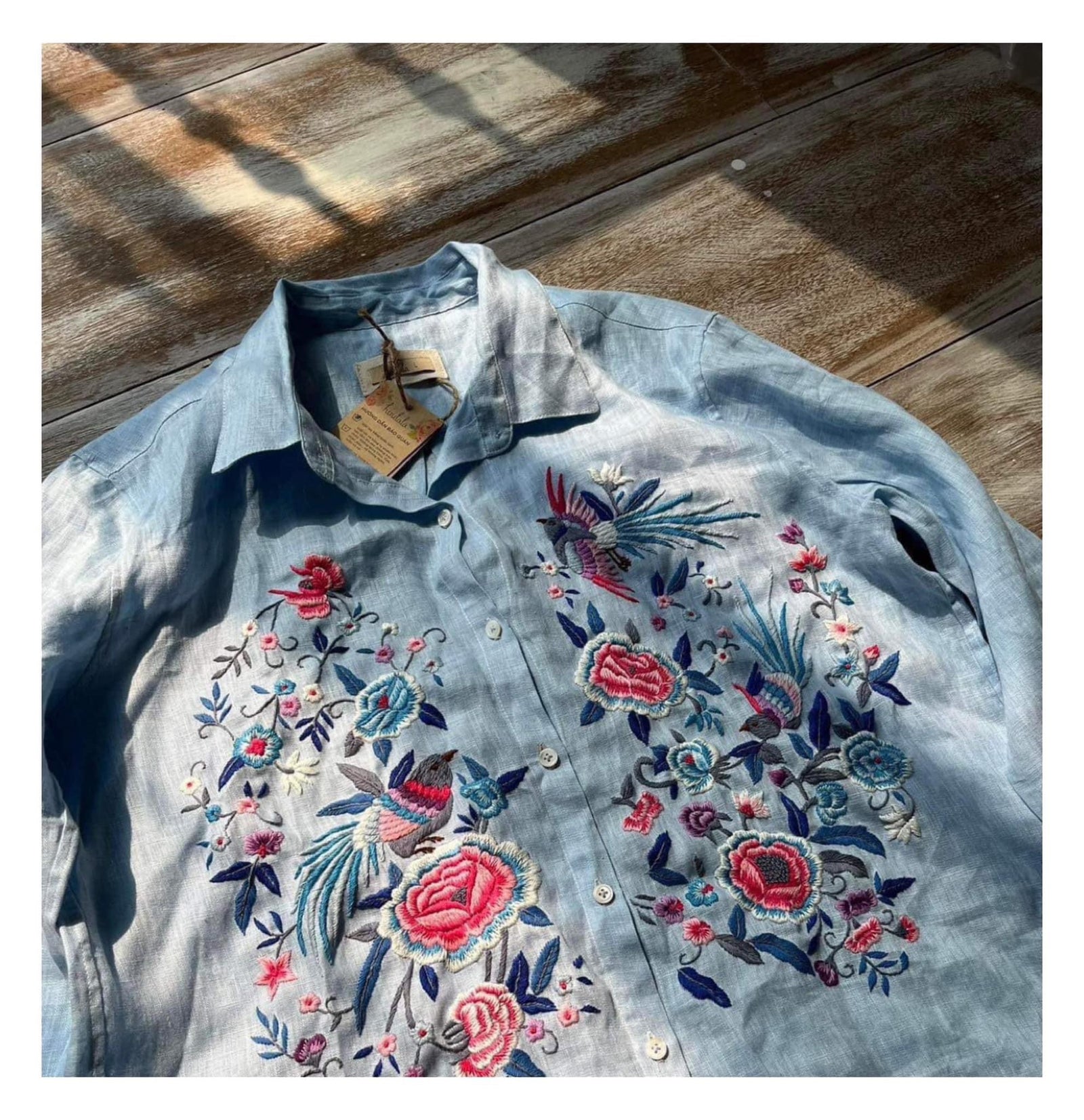 "Zoya embroidered linen shirt by Huulala, light blue with pink floral embroidery, Vietnamese-inspired design."