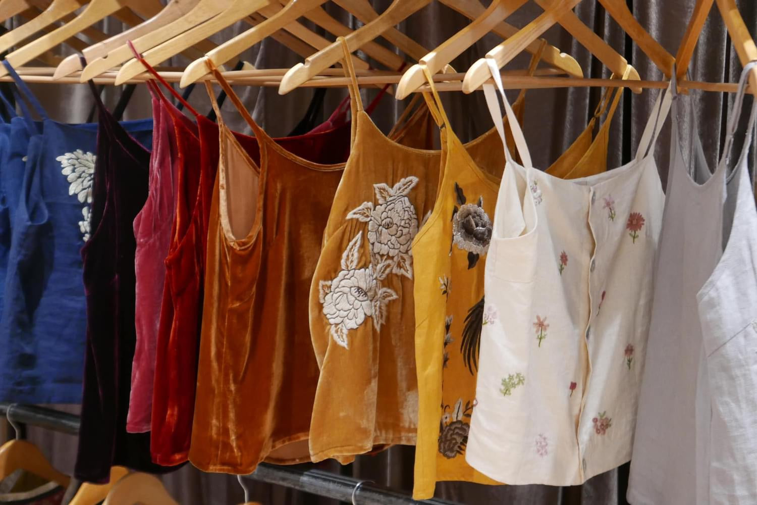"Mai - Embroidered linen tank top in cream by Huulala, featuring red floral patterns, Vietnamese-inspired design."