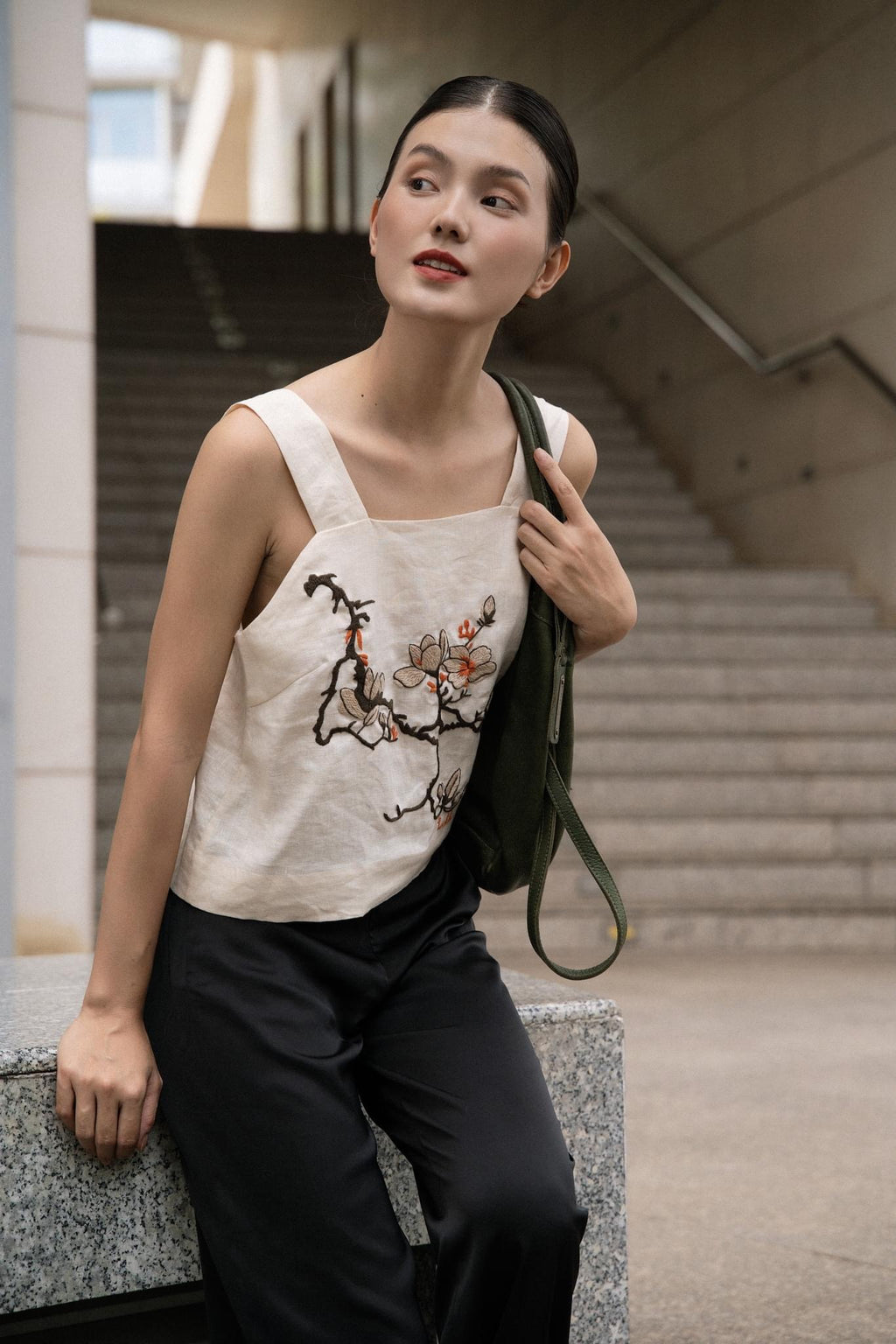 "Magnolia" white embroidered linen top by Huulala, featuring modern floral patterns in red and black.
