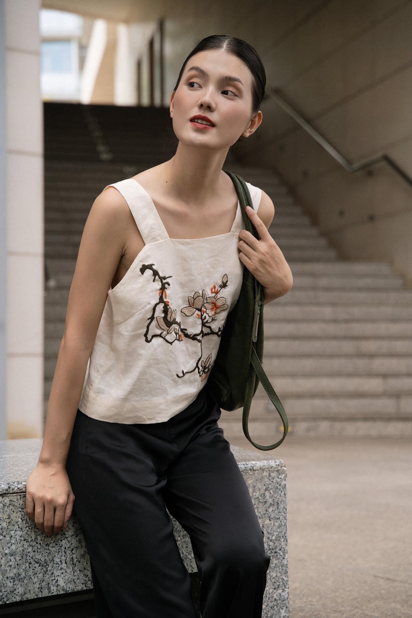 "Magnolia" white embroidered linen top by Huulala, featuring modern floral patterns in red and black.