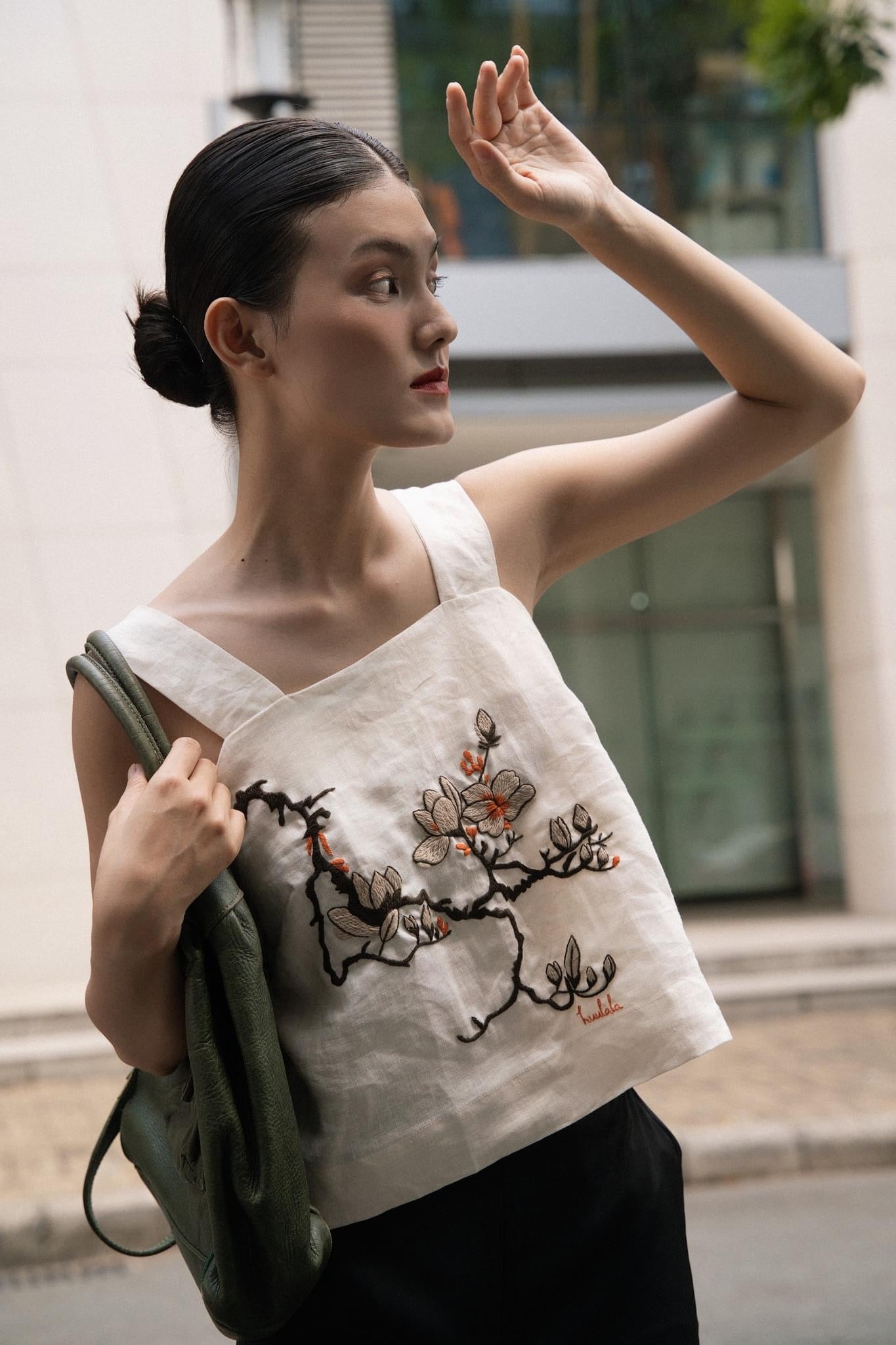 "Magnolia" white embroidered linen top by Huulala, featuring modern floral design in red and black.