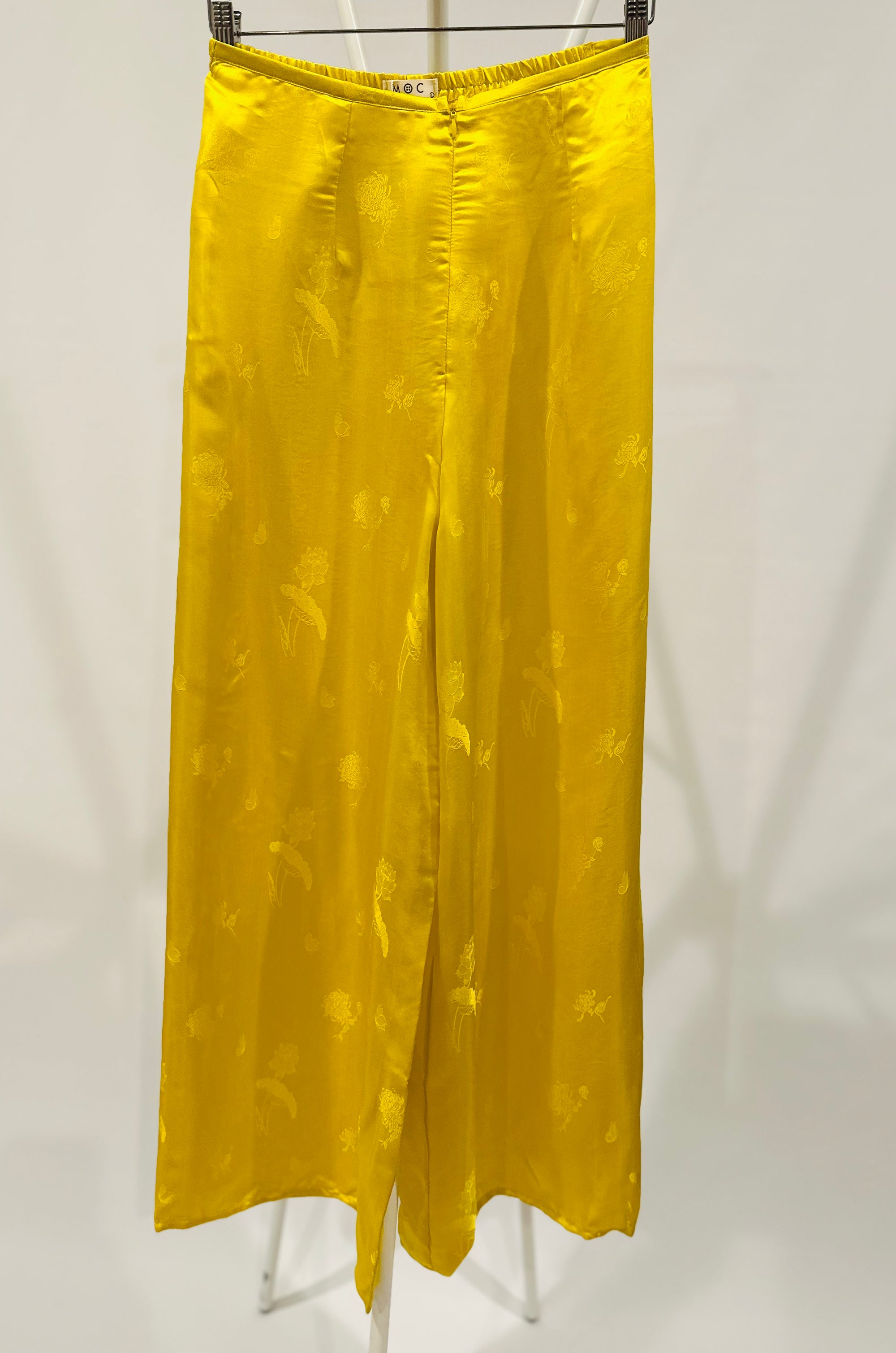 "Traditional Vietnamese Ao Dai pants in yellow jacquard silk with lotus pattern by Moc."