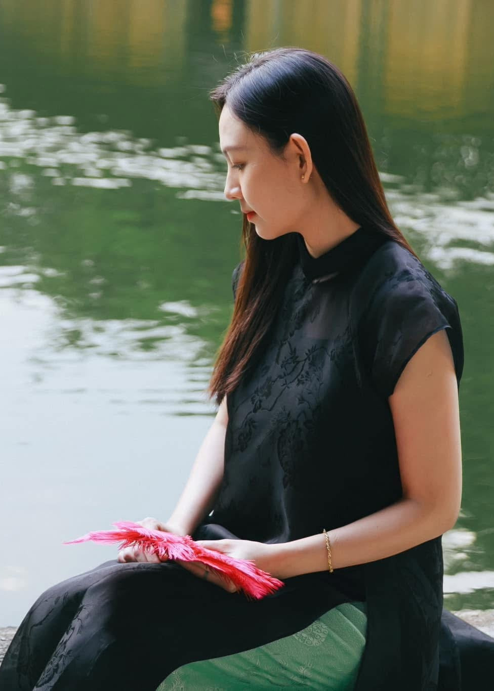 Black sleeveless silk áo dài with floral jacquard detail and green pants - Vietnamese traditional dress by Nam Phuong Y