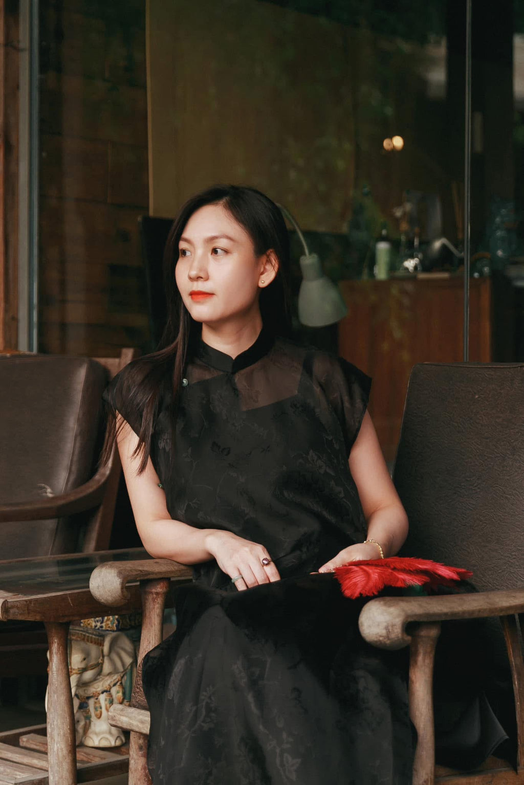 Black sleeveless silk áo dài with floral jacquard pattern and green pants detail view by Nam Phuong Y