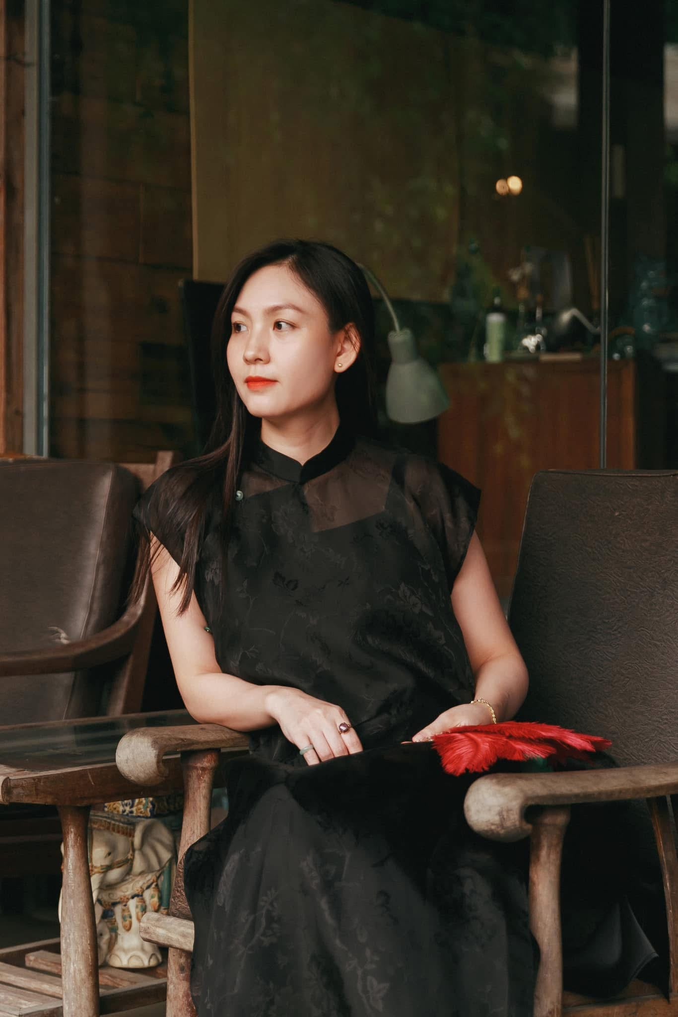 Black sleeveless silk áo dài with floral jacquard pattern and green pants detail view by Nam Phuong Y