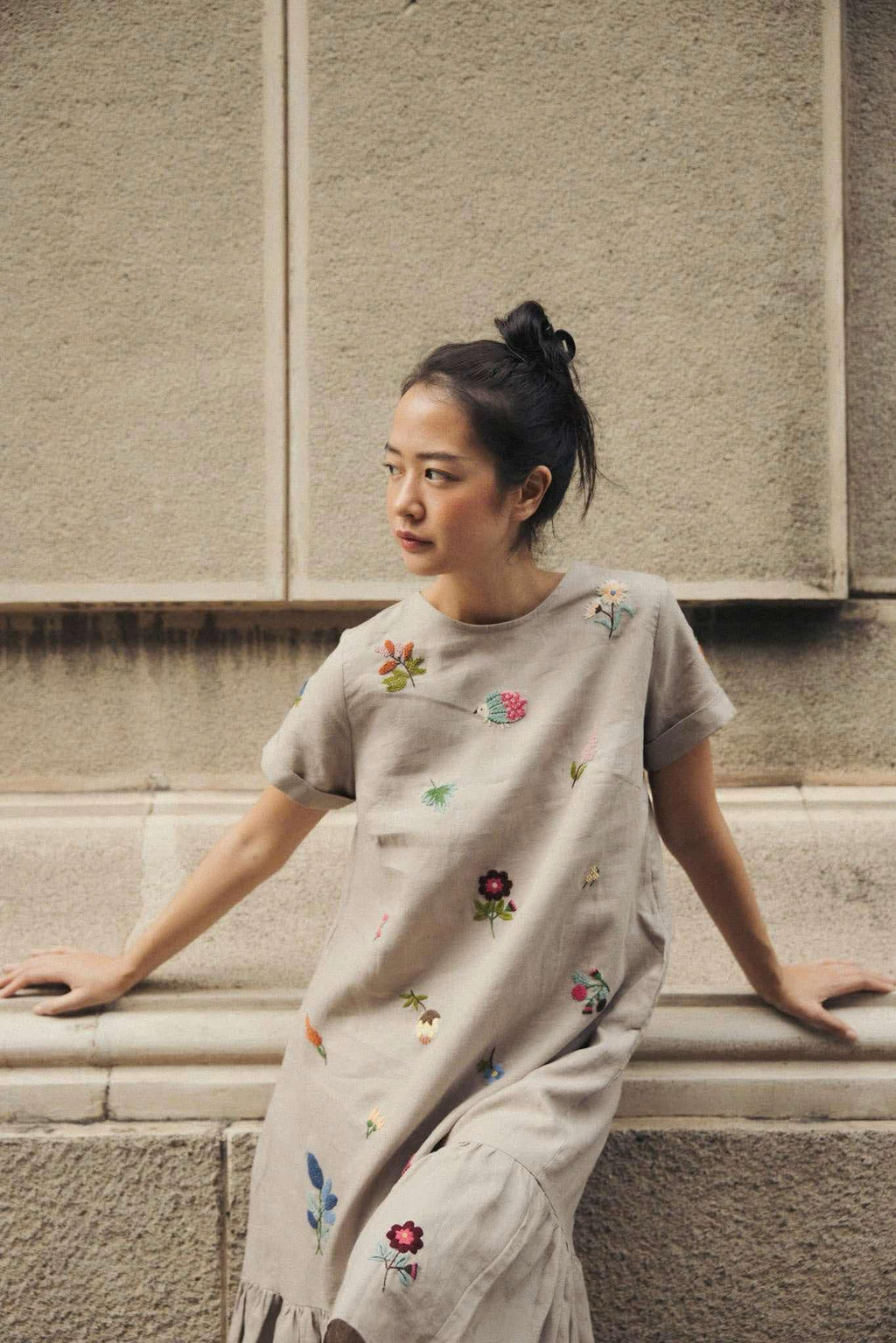 "Jacky" embroidered linen ruffled dress in gray by Huulala, featuring colorful floral patterns.