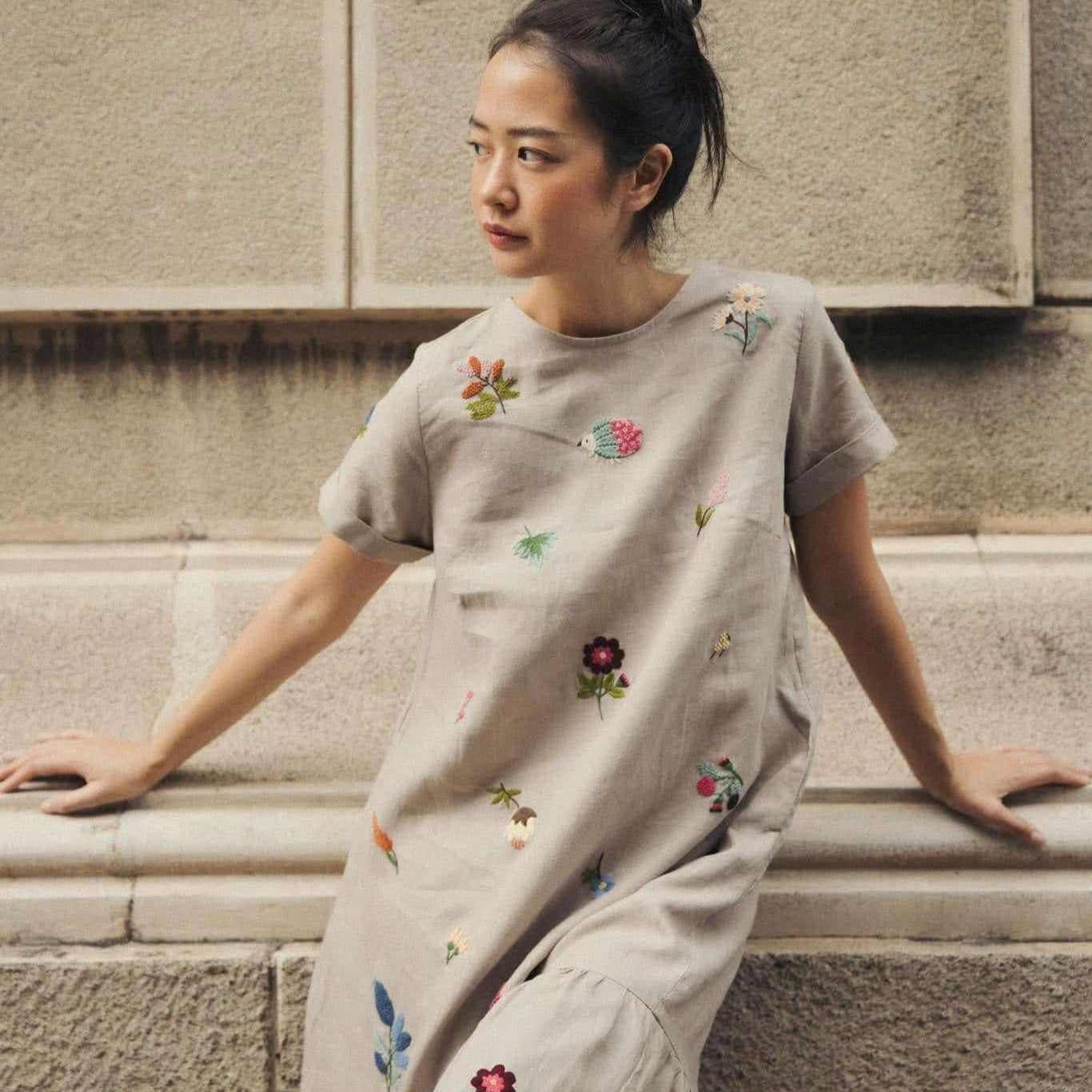 "Jacky" embroidered linen ruffled dress in gray by Huulala, featuring colorful floral patterns.