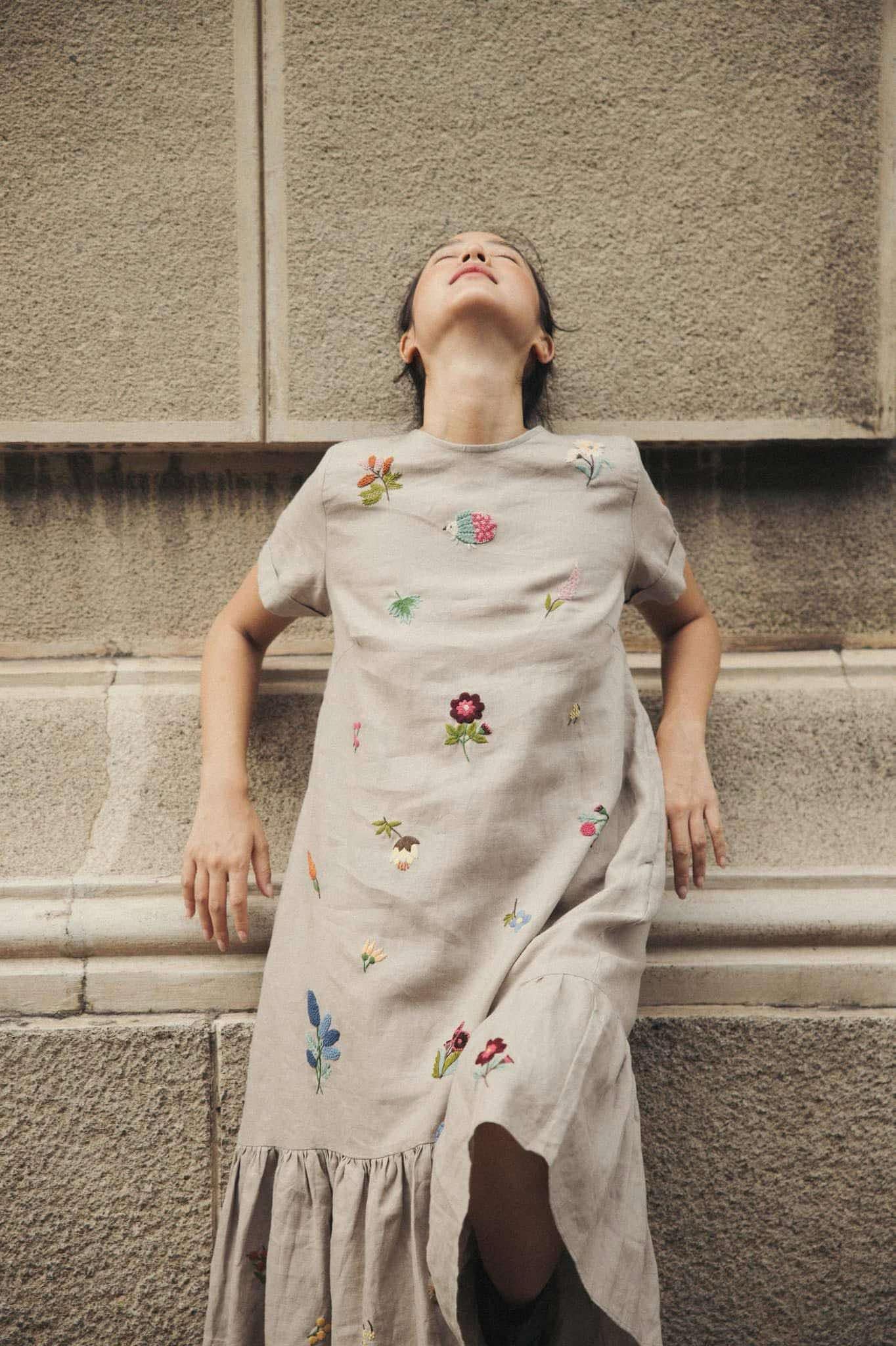 "Jacky" embroidered linen ruffled dress in gray by Huulala, featuring colorful floral patterns.
