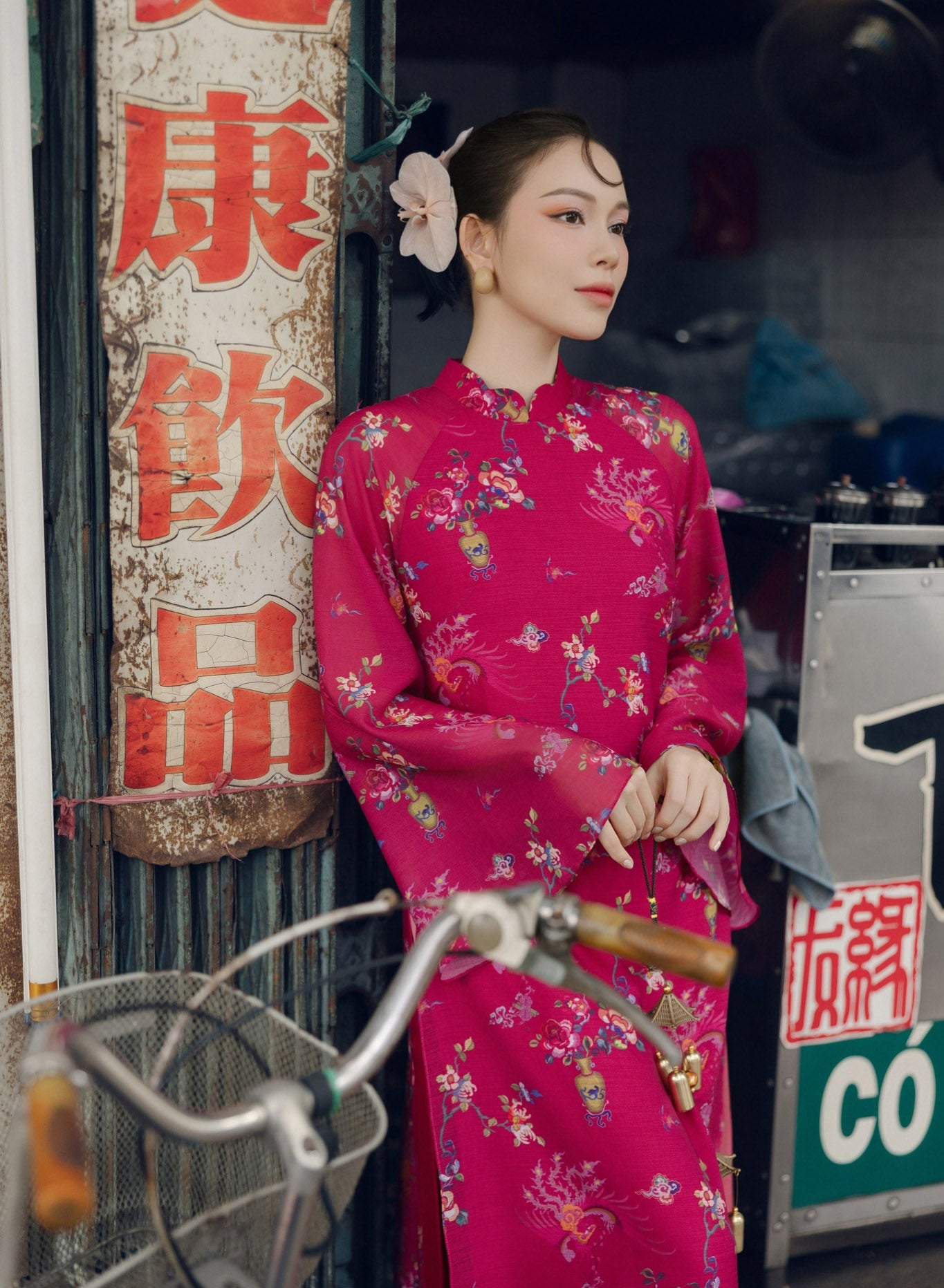 "Giang Chi Ao dai in magenta silk by Lalin, featuring artisan floral patterns, traditional Vietnamese dress."