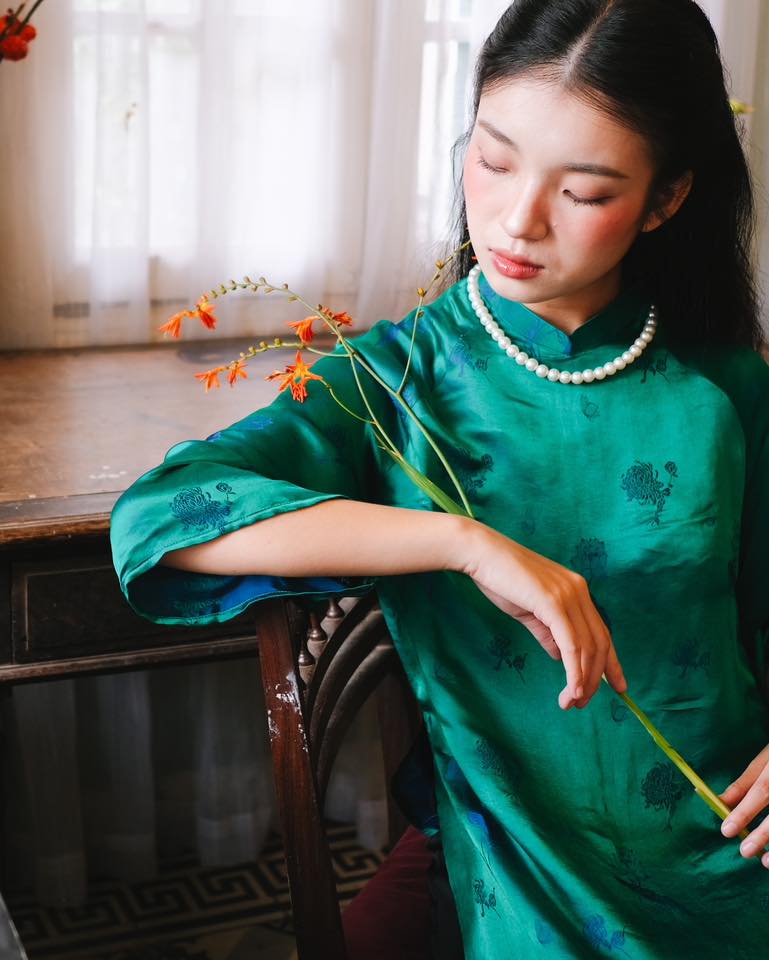 "Green silk 'Lien Hoa' Ao Dai set by Moc, traditional Vietnamese dress with modern pattern."