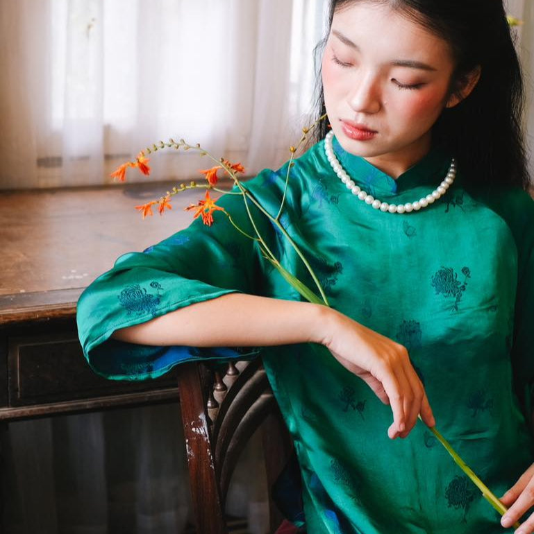 "Green silk 'Lien Hoa' Ao Dai set by Moc, traditional Vietnamese dress with modern pattern."