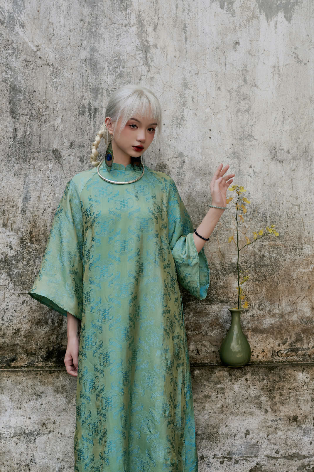 "Loc Tho Ao Dai set in jade wormsilk, traditional Vietnamese dress with red jacquard pattern, artisan-crafted."
