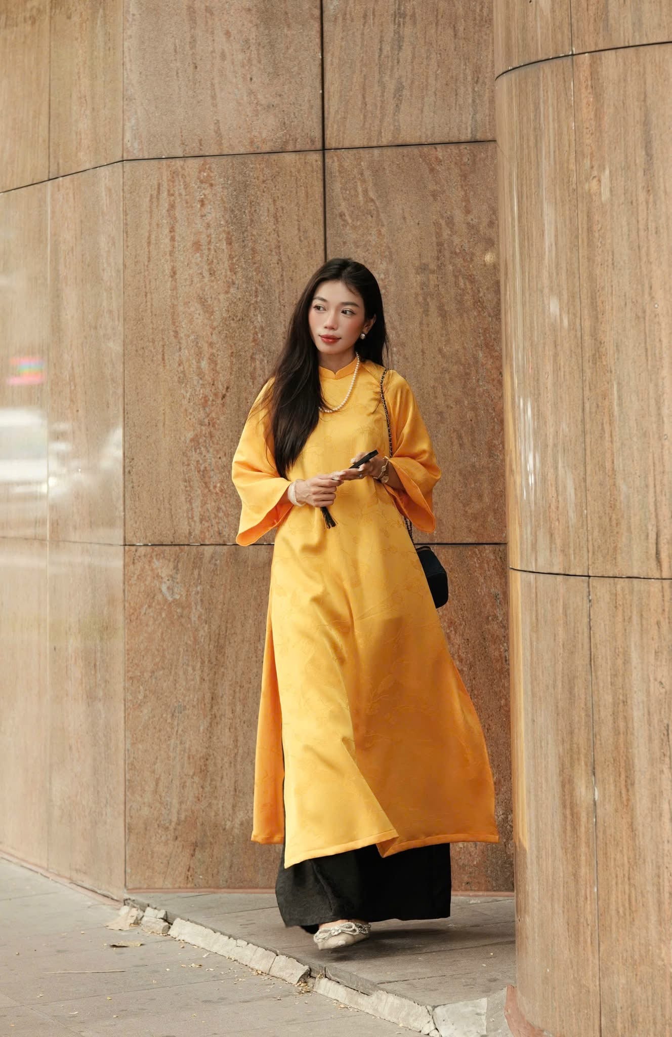 "Traditional Vietnamese Ao dai in yellow jacquard silk with black peacock wormsilk pants"