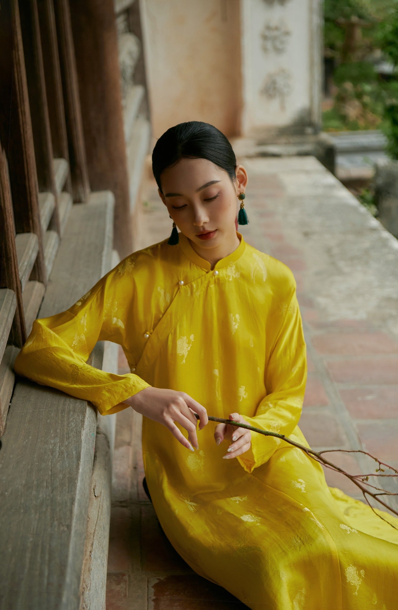 "Traditional Vietnamese Ao Dai in yellow silkworm silk by Moc, featuring artisan woven patterns."