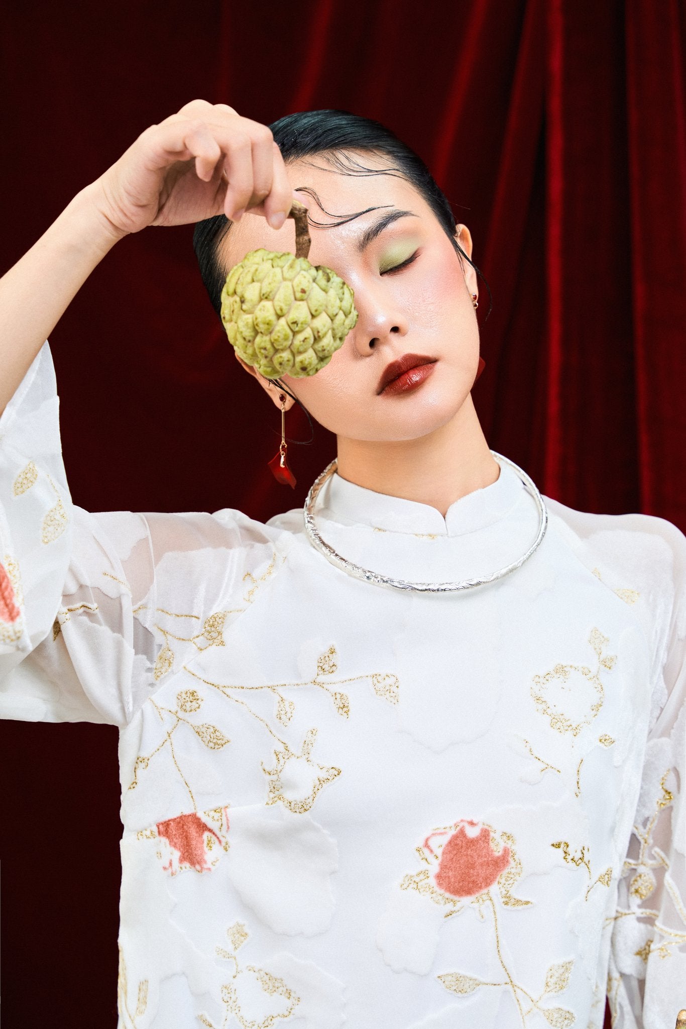 "Embroidered sheer chiffon Ao dai in blush coral with floral patterns, traditional Vietnamese dress by Moc."