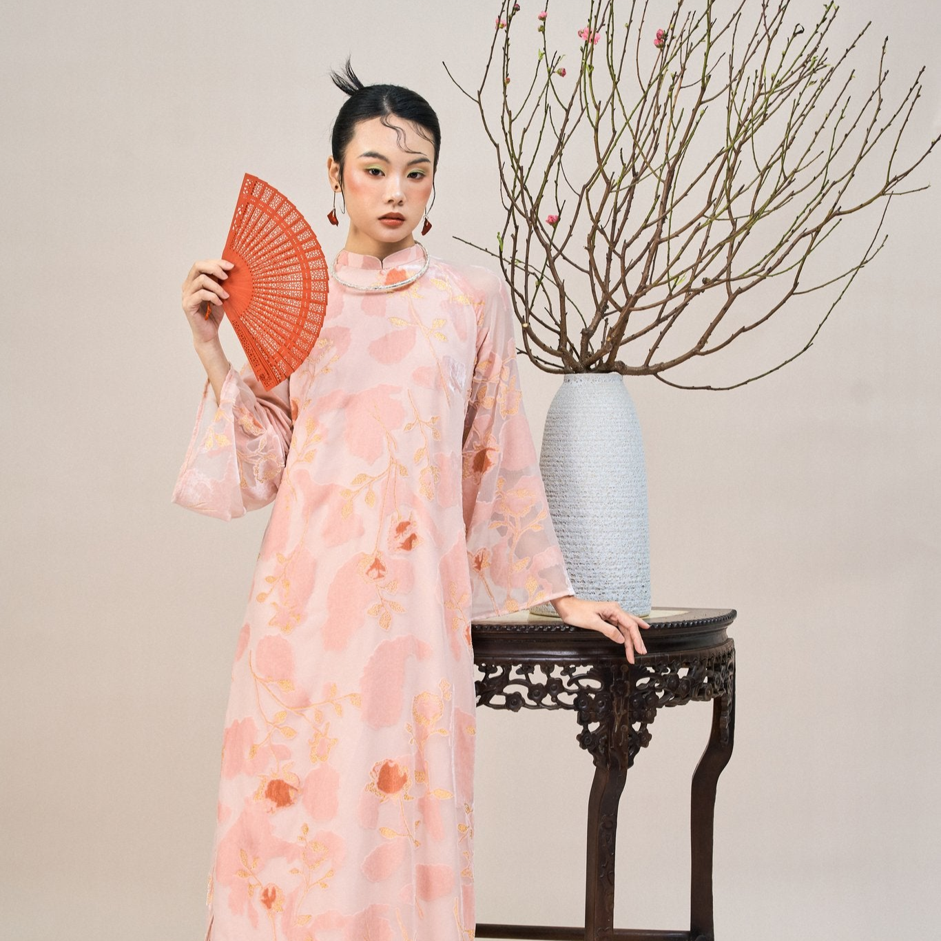 "Embroidered sheer chiffon Ao dai set in blush coral with floral patterns, traditional Vietnamese dress."