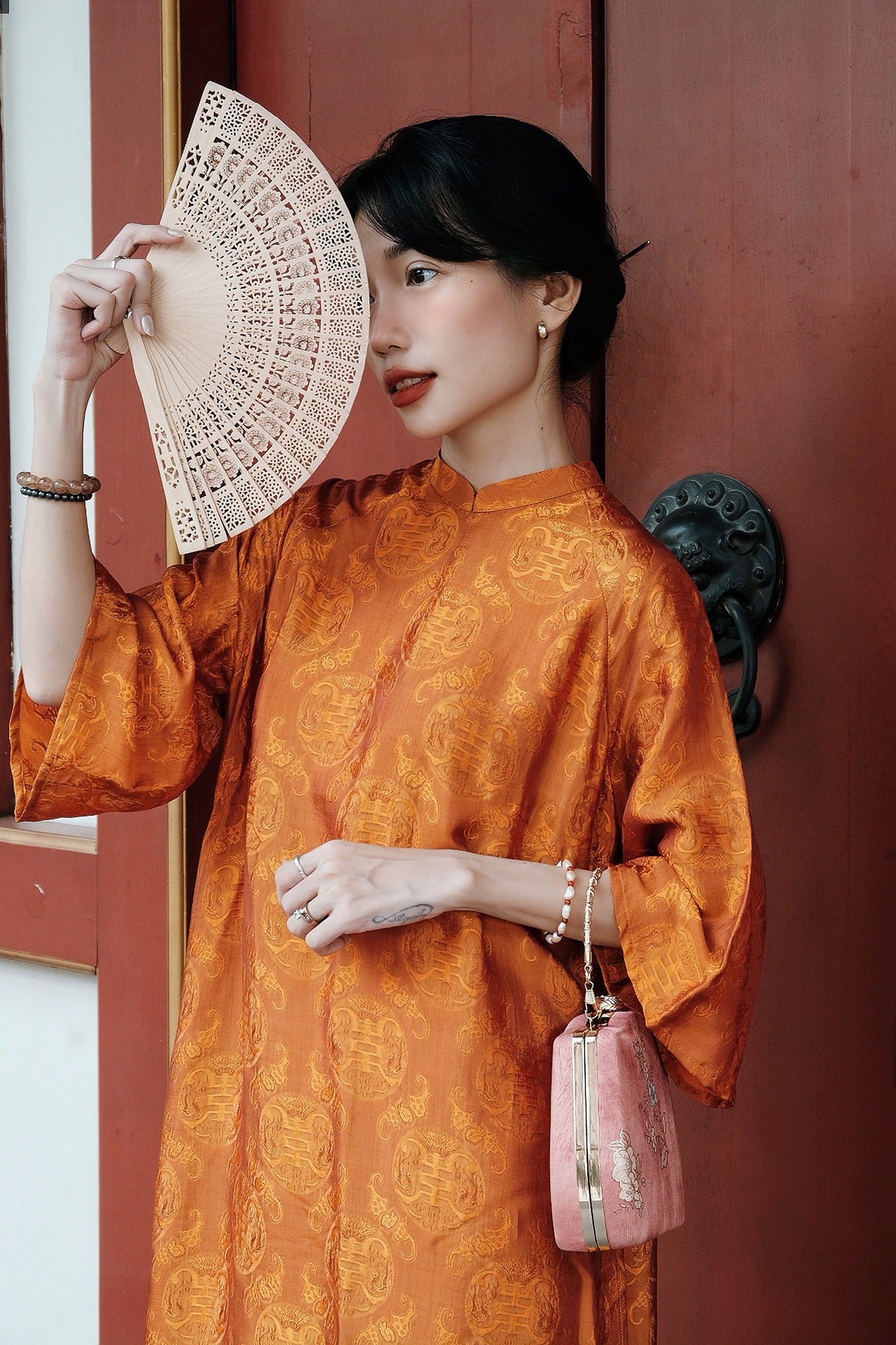 "Tho Doi Ao Dai set in orange wormsilk, traditional Vietnamese dress with jacquard patterns, cultural authenticity"