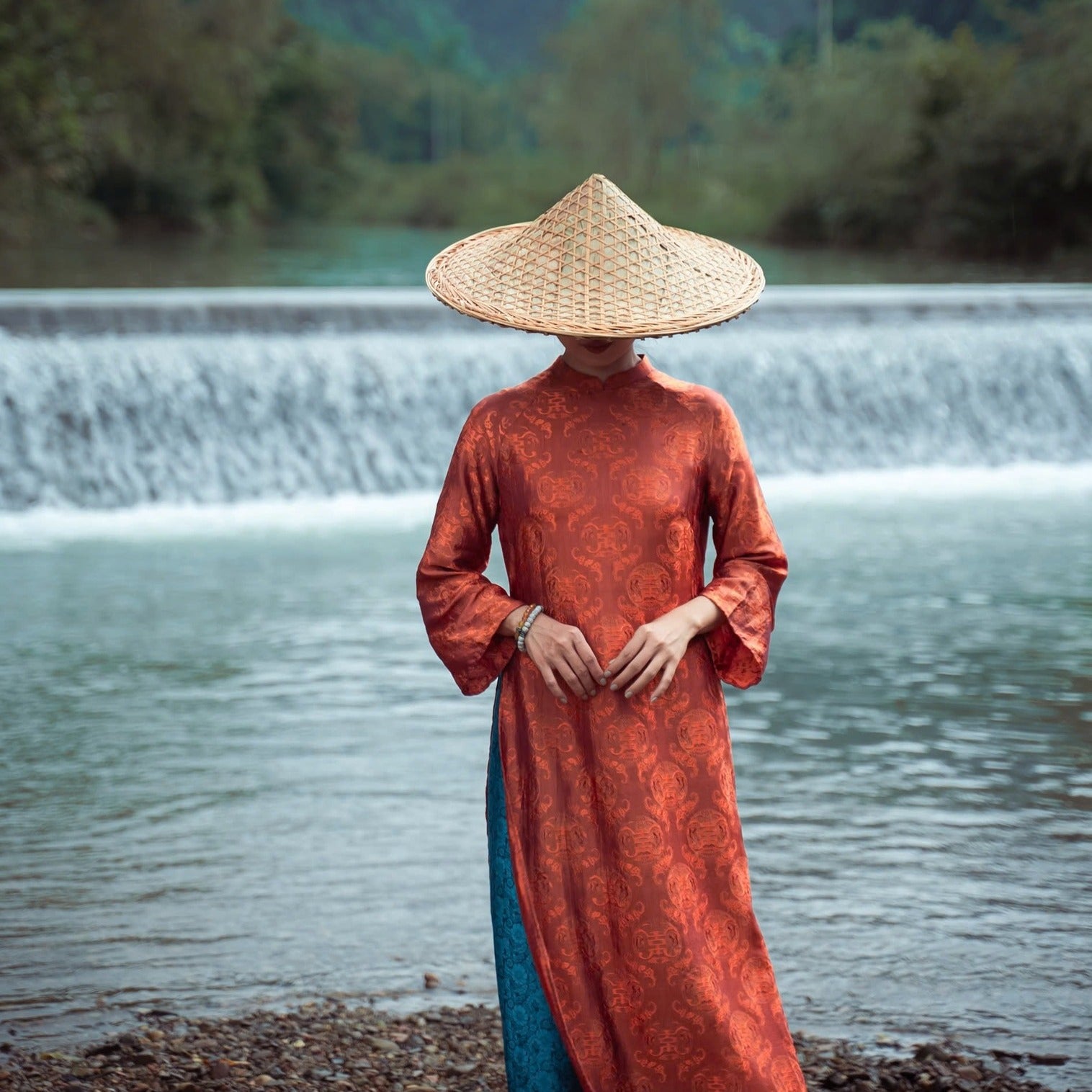 "Tho Doi Ao Dai set in orange wormsilk, traditional Vietnamese dress by Moc, with jacquard patterns."